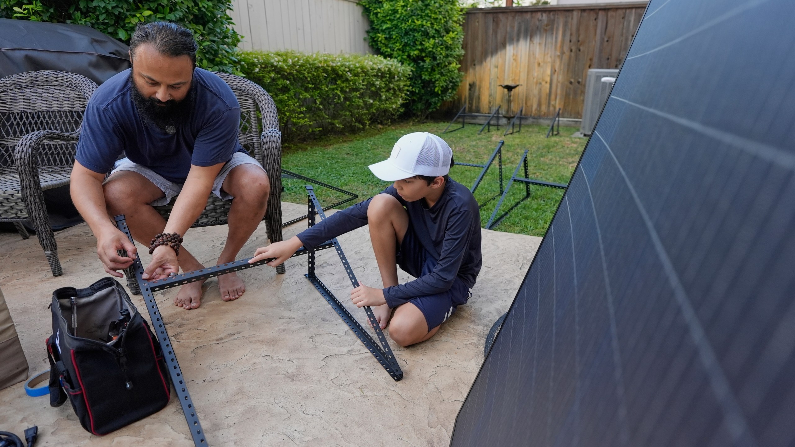 Bhavin Misra, left, and his son, Rumi, 10, assemble a Craftstrom Solar plug-in kit at their home Tuesday, Aug. 5, 2025, in Houston. (AP Photo/David J. Phillip)