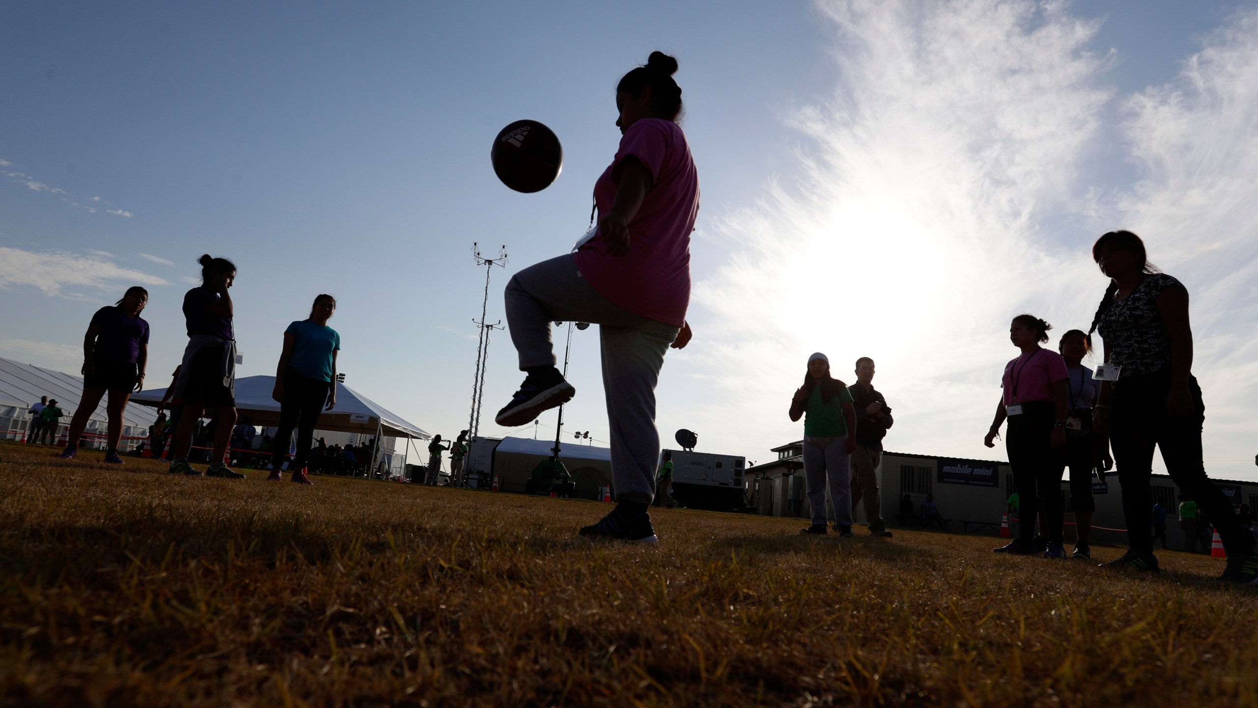 FILE - Immigrants play soccer at a new U.S. government holding center for migrant children in Carrizo Springs, Texas, July 9, 2019. (AP Photo/Eric Gay, File)