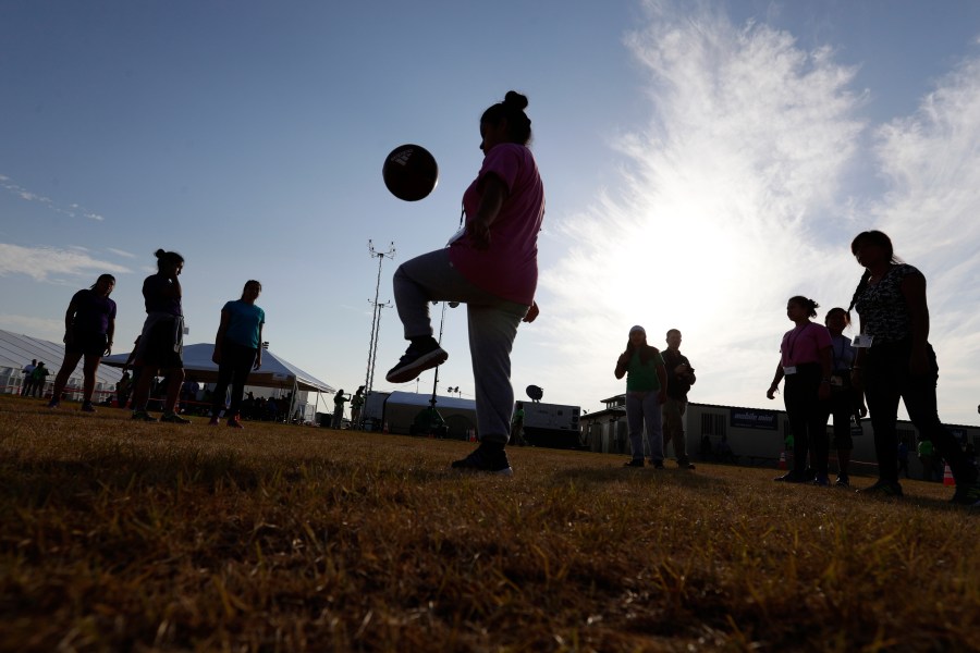 FILE - Immigrants play soccer at a new U.S. government holding center for migrant children in Carrizo Springs, Texas, July 9, 2019. (AP Photo/Eric Gay, File)