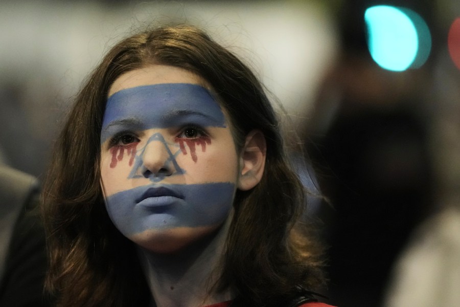 A woman with her face painted in the colors of the Israeli flag takes part in a protest demanding the end of the war, the immediate release of hostages held by Hamas in the Gaza Strip, and against Prime Minister Benjamin Netanyahu's government in Tel Aviv, Saturday, Aug. 16, 2025. (AP Photo/Mahmoud Illean)