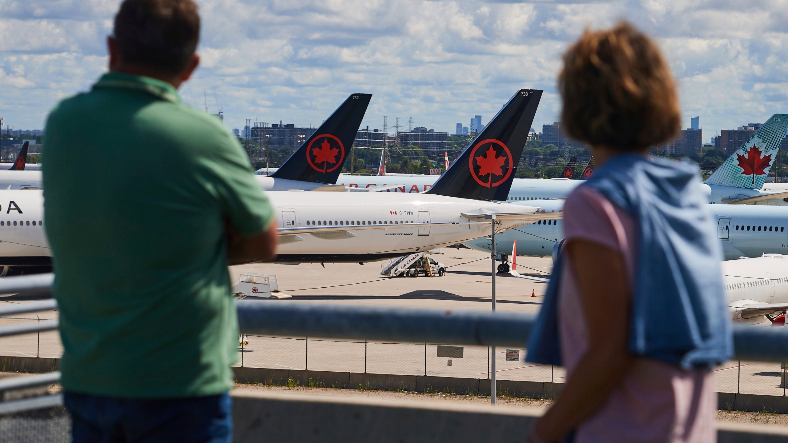 Travelers look out over grounded Air Canada planes as flight attendants picket at Pearson International Airport in Toronto, Monday, Aug. 18, 2025. (Sammy Kogan/The Canadian Press via AP)