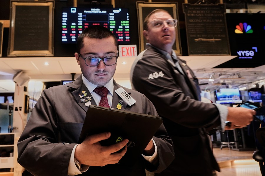 Traders Drew Cohen, left, and Ryan Falvey work on the floor of the New York Stock Exchange, Monday, Aug. 18, 2025. (AP Photo/Richard Drew)