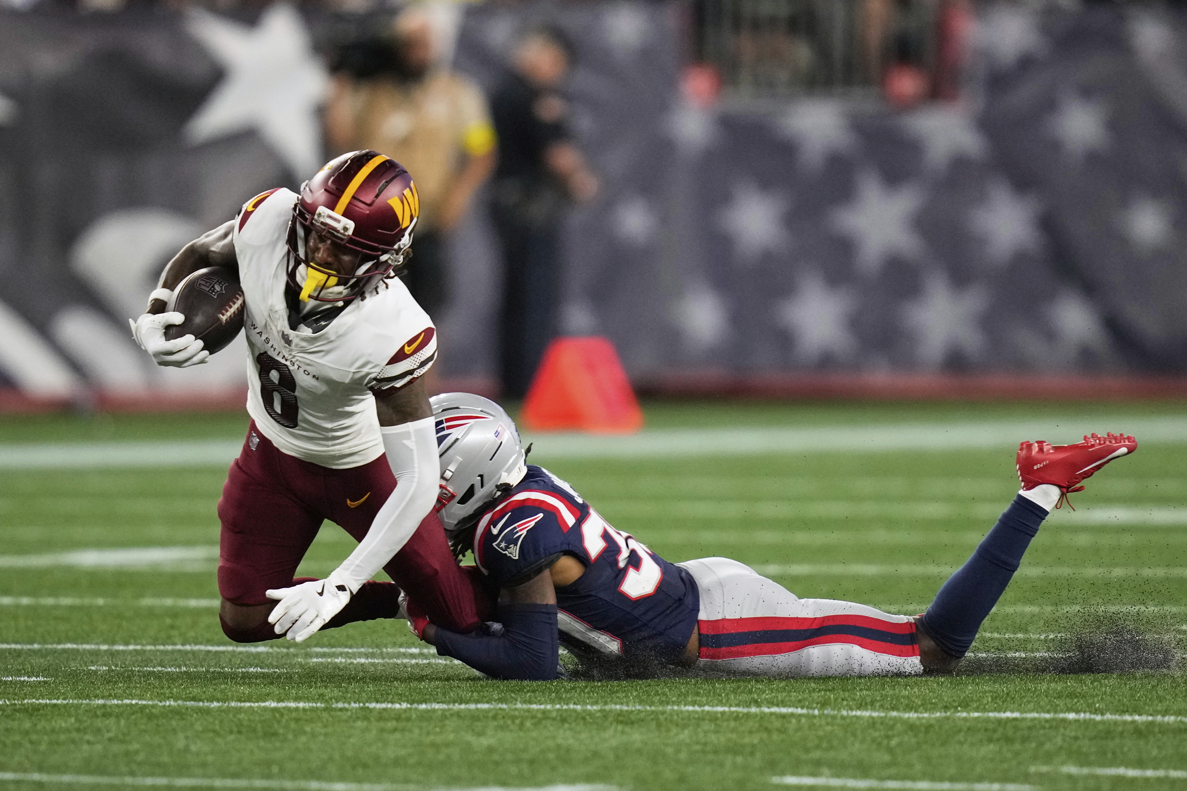 New England Patriots cornerback DJ James, right, tackles Washington Commanders running back Brian Robinson Jr. (8) during the first half of an NFL preseason football game Friday, Aug. 8, 2025, in Foxborough, Mass. (AP Photo/Charles Krupa)