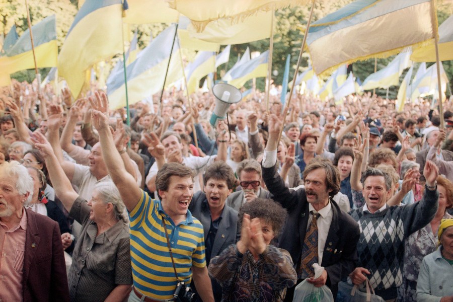 FILE - People wave Ukrainian national flags as they gather outside the parliament building during a pro-independence rally, in Kyiv, Sept. 4, 1991. (AP Photo/Dusan Vranic, File)