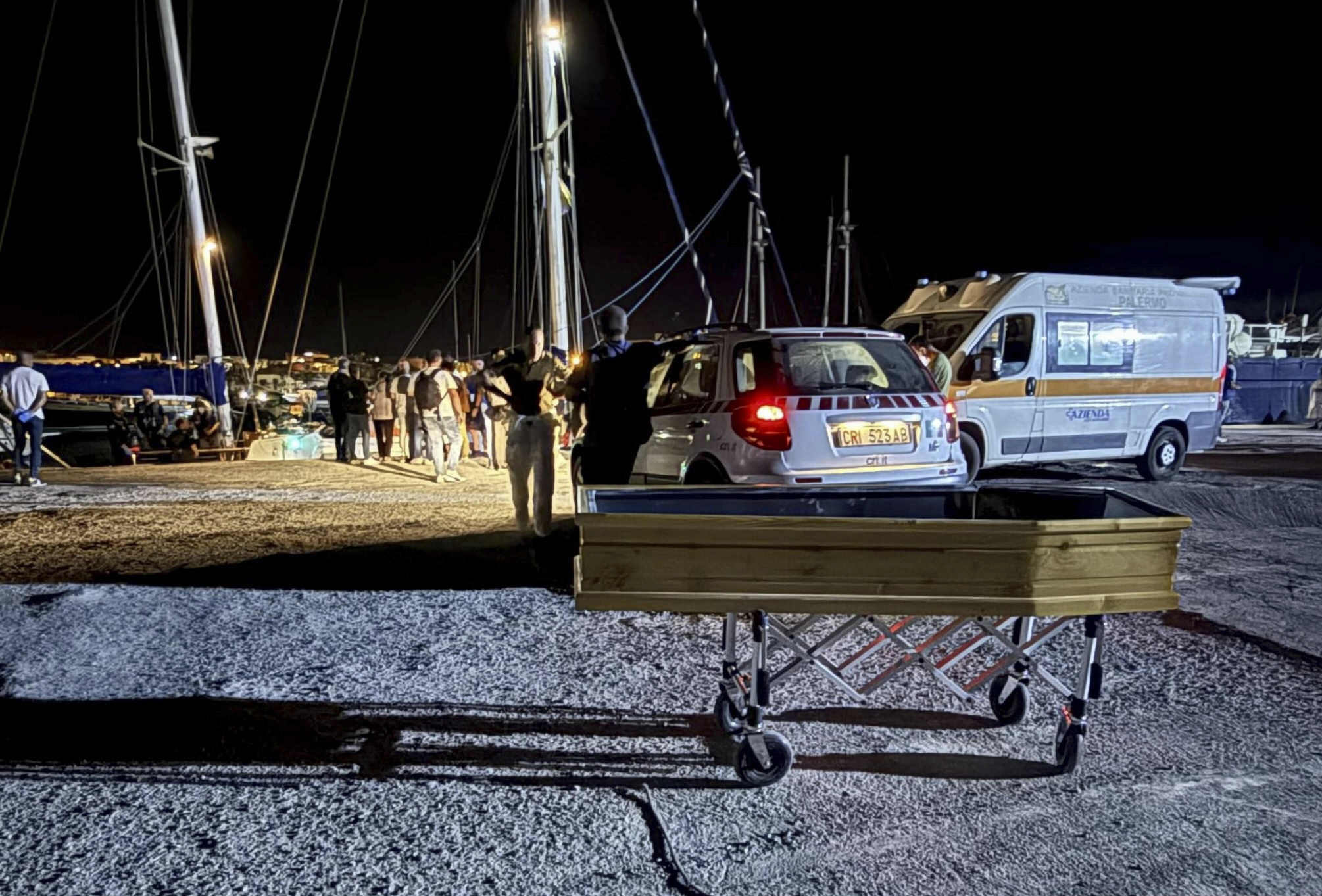 In this photo provided by RESQSHIP, a coffin on the dock of the Sicilian island of Lampedusa, early Saturday, Aug. 23, 2025 as migrants that were rescued by the crew of the vessel NADIR operated by the organization RESQSHIP arrive at the harbour. (Lars/RESQSHIP via AP)