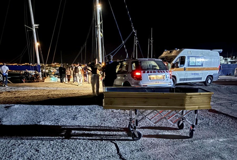 In this photo provided by RESQSHIP, a coffin on the dock of the Sicilian island of Lampedusa, early Saturday, Aug. 23, 2025 as migrants that were rescued by the crew of the vessel NADIR operated by the organization RESQSHIP arrive at the harbour. (Lars/RESQSHIP via AP)