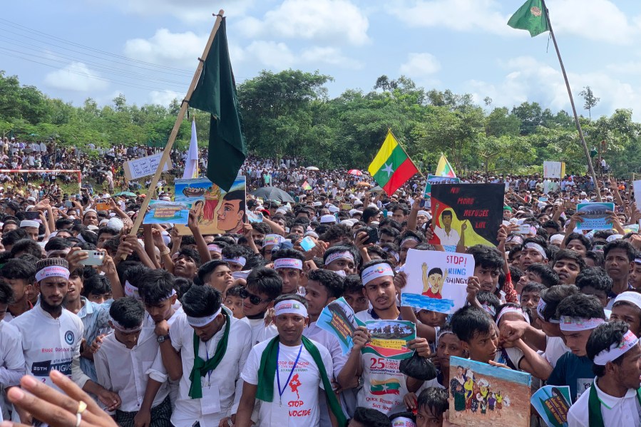 Rohingya refugees gather as they hold placards and flags to demand safe return to Myanmar's Rakhine state as they mark the eighth anniversary of their mass exodus at their refugee camp at Kutupalong in Cox's Bazar district, Bangladesh, Monday, Aug. 25, 2025. (AP Photo/Shafiqur Rahman)
