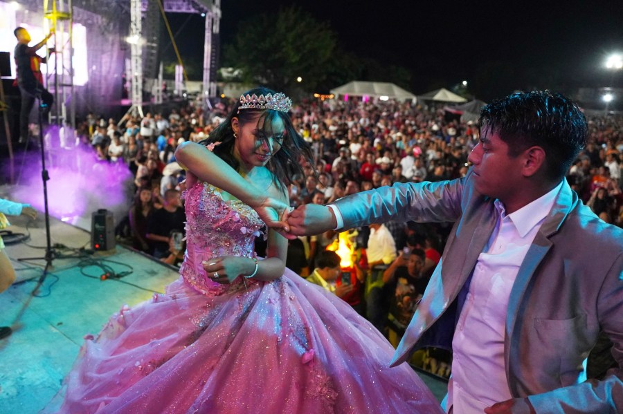 Isela Anali Santiago Morales dances during her 15th birthday party at a stadium in Axtla de Terrazas, Mexico, Saturday, Aug. 23, 2025, organized by the community after her father's social media appeal drew support following her first sparsely attended party. (AP Photo/Mauricio Palos)