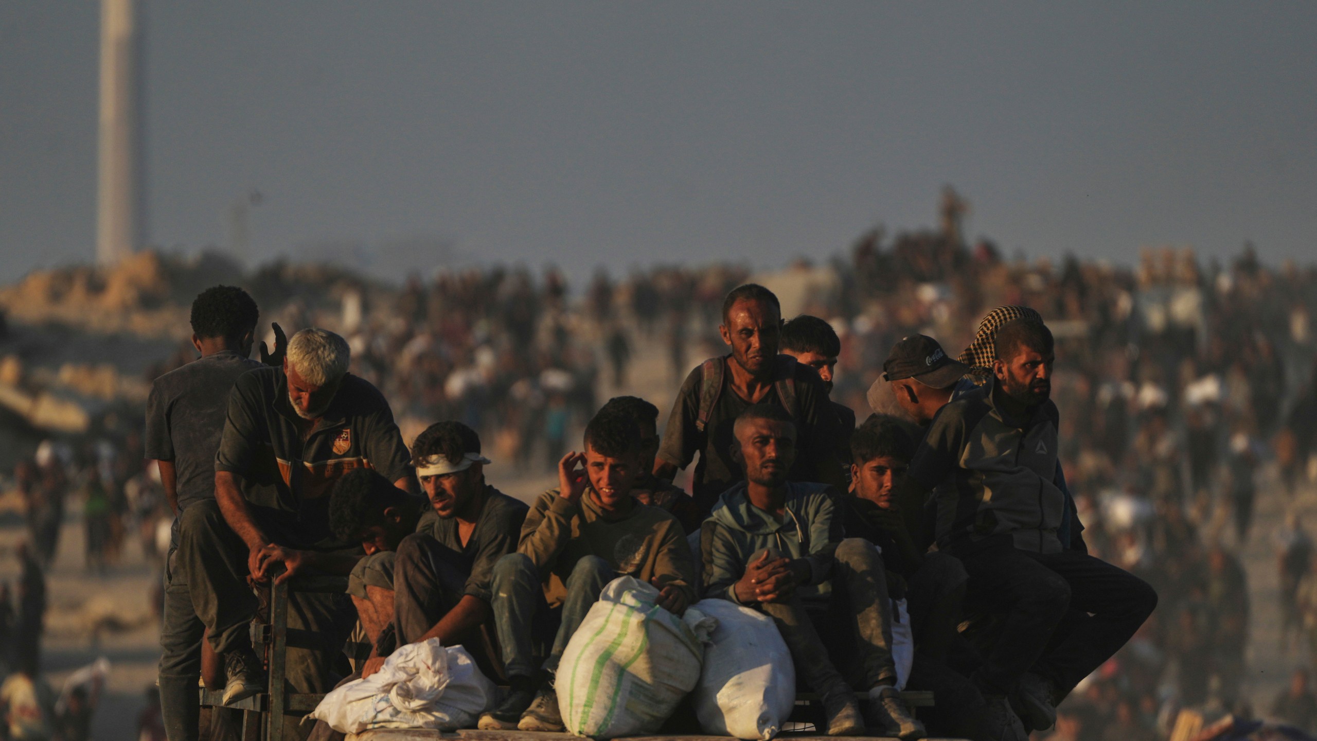 Palestinians carry sacks of flour unloaded from a humanitarian aid convoy that reached Gaza City from the northern Gaza Strip, Sunday, Aug. 24, 2025. (AP Photo/Abdel Kareem Hana)