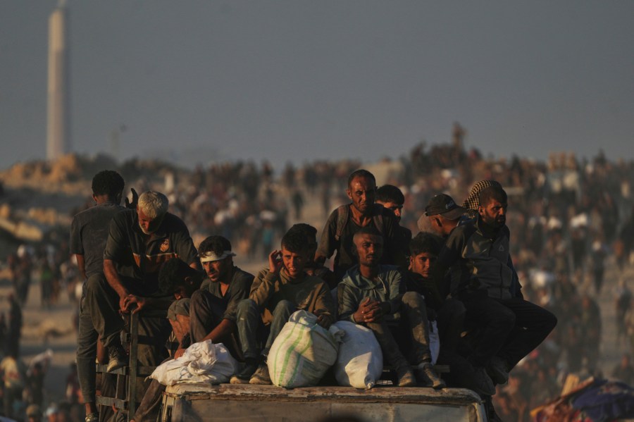Palestinians carry sacks of flour unloaded from a humanitarian aid convoy that reached Gaza City from the northern Gaza Strip, Sunday, Aug. 24, 2025. (AP Photo/Abdel Kareem Hana)