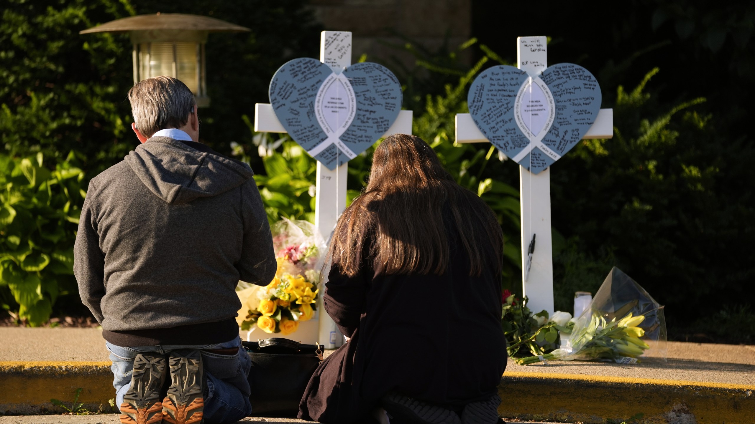 Tim and Katharine Barr kneel and pray at a memorial at Annunciation Catholic Church after Wednesday's school shooting, Thursday, Aug. 28, 2025, in Minneapolis. (AP Photo/Abbie Parr)