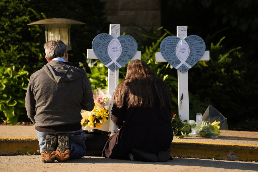 Tim and Katharine Barr kneel and pray at a memorial at Annunciation Catholic Church after Wednesday's school shooting, Thursday, Aug. 28, 2025, in Minneapolis. (AP Photo/Abbie Parr)