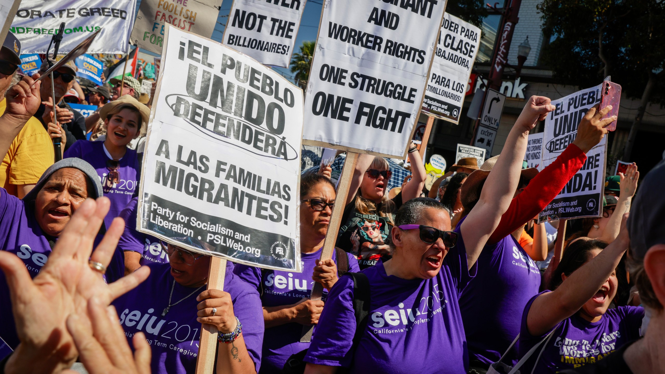 Raven Winchell, of Seui 2015 Long Term Care Givers, raises her first as hundreds gather to protest the Trump Administration while calling for workers over billionaires in the Mission District in San Francisco, Calif., Monday, Sept. 1, 2025. (Bronte Wittpenn/San Francisco Chronicle via AP)