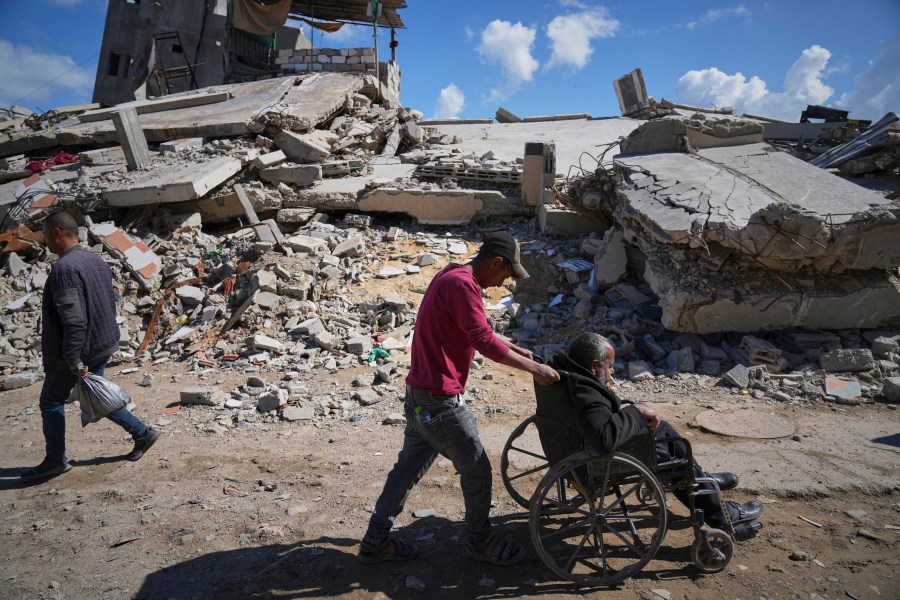 FILE - Wasem Attiya pushes his father, Mohamed, 54, in a wheelchair as they head to Shifa hospital in Gaza City for a dialysis session, Monday, April 14, 2025. (AP Photo/Jehad Alshrafi, File)