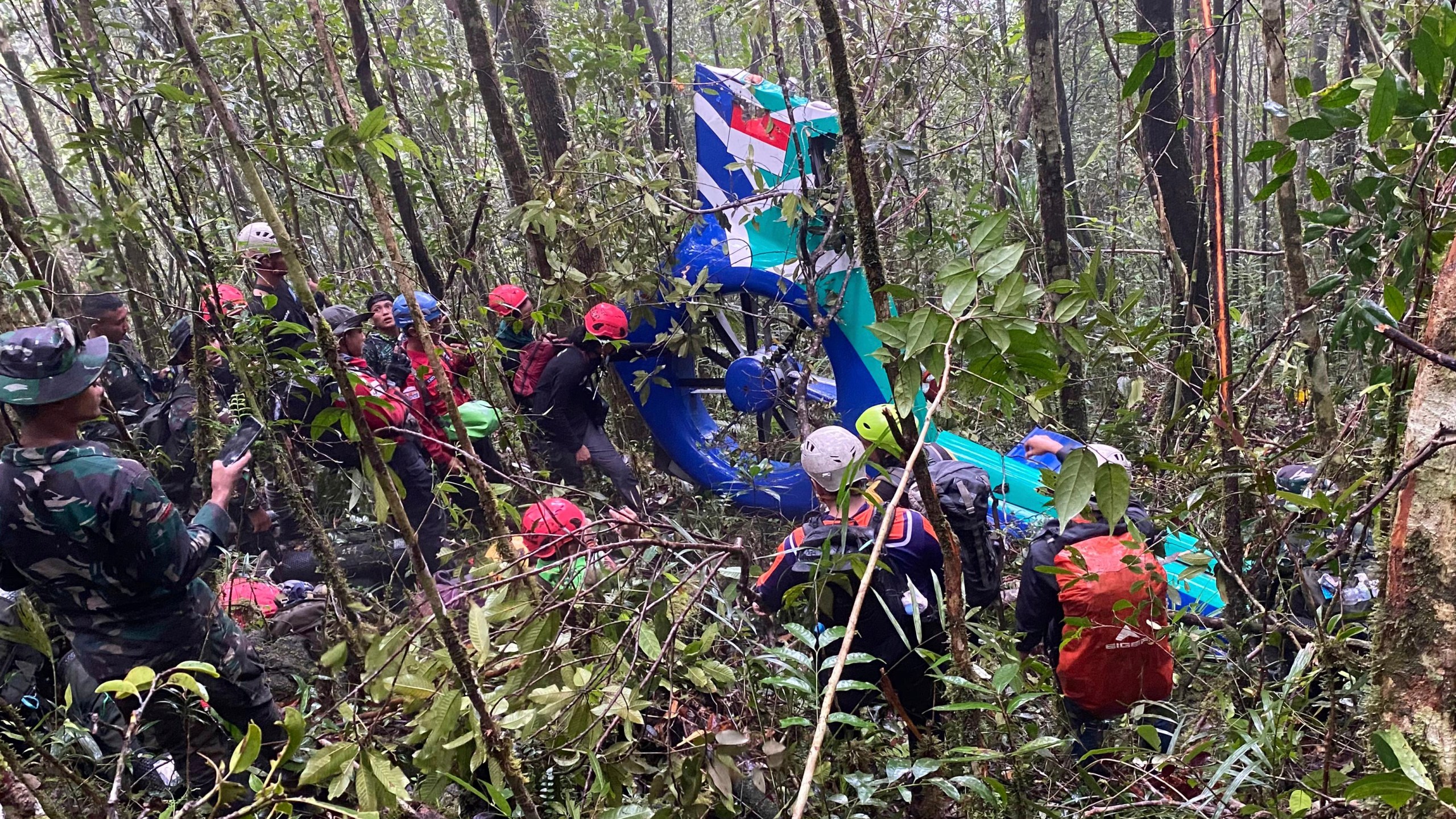In this photo released by Indonesia's National Search and Rescue Agency (BASARNAS) on Thursday, Sept. 4, 2025, rescuers inspect the wreckage of a helicopter that crashed with passengers on board, in Tanah Bumbu, South Kalimantan, Indonesia. (BASARNAS via AP)