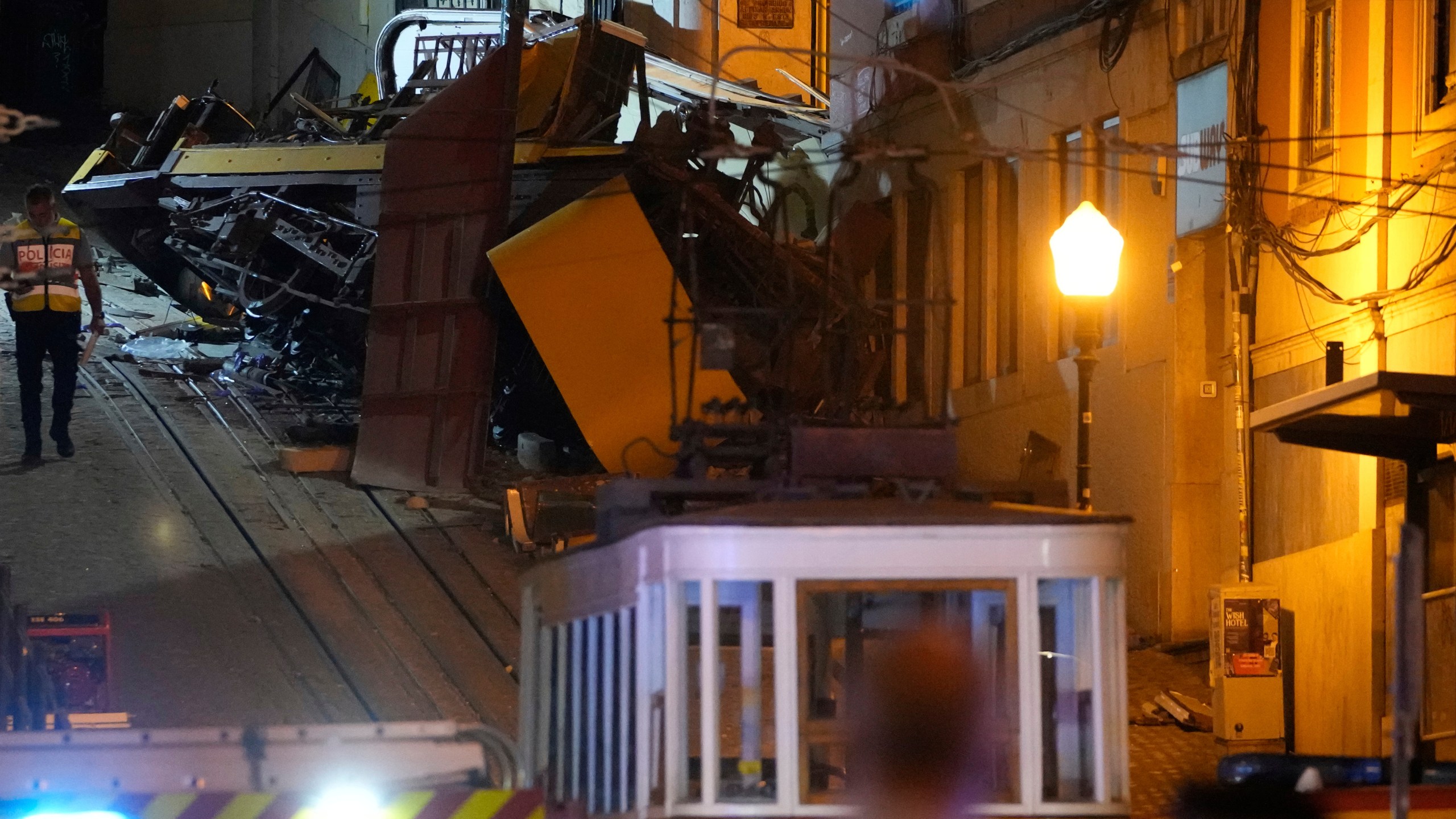 A police officer walks at the site of a derailed electric streetcar in Lisbon, Portugal, Wednesday, Sept. 3, 2025. (AP Photo/Armando Franca)
