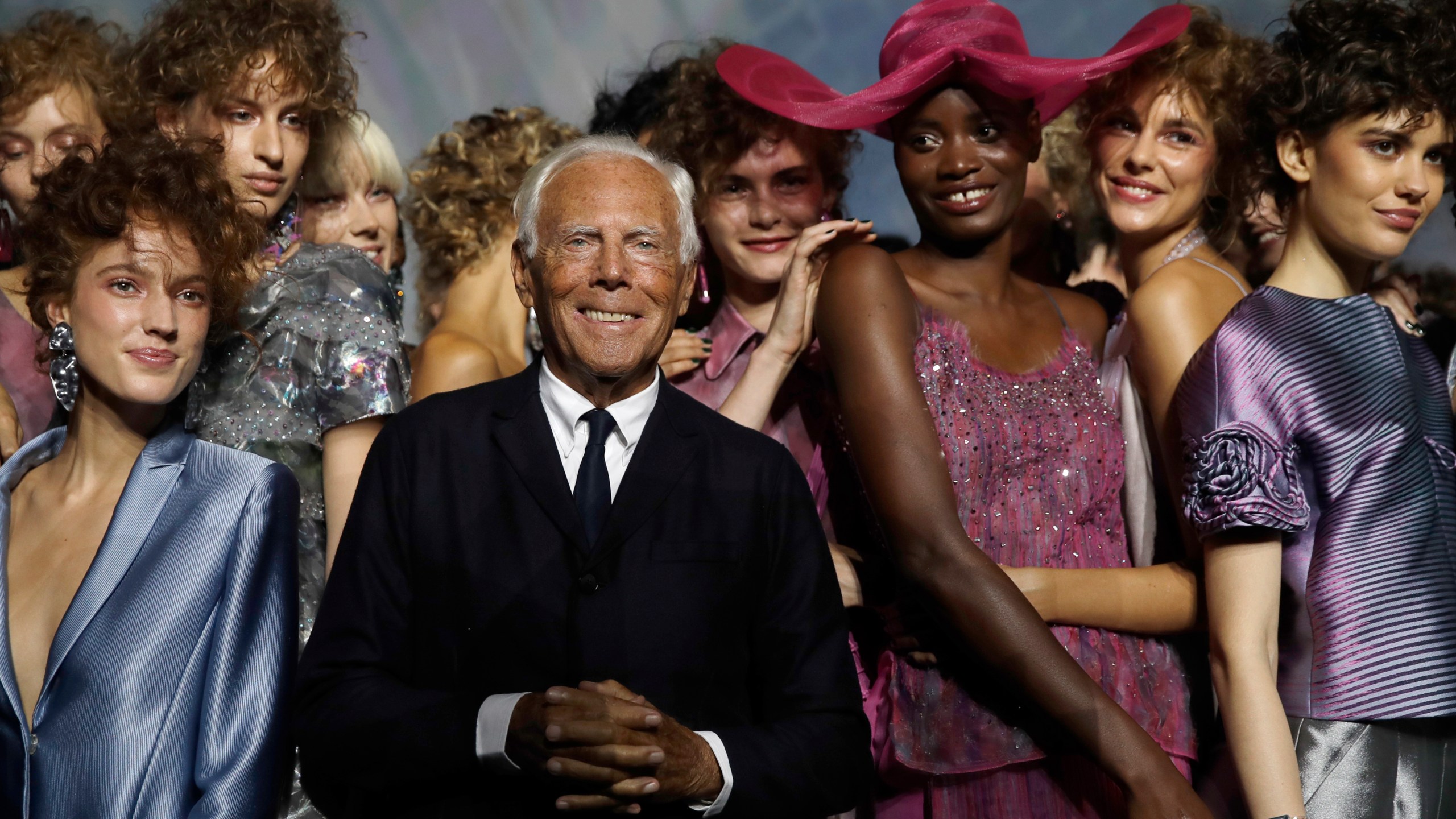 FILE - Designer Giorgio Armani, centre, poses with models at the end of his women's 2019 Spring-Summer collection, unveiled during the Fashion Week in Milan, Italy, Sunday, Sept. 23, 2018. (AP Photo/Luca Bruno, File)