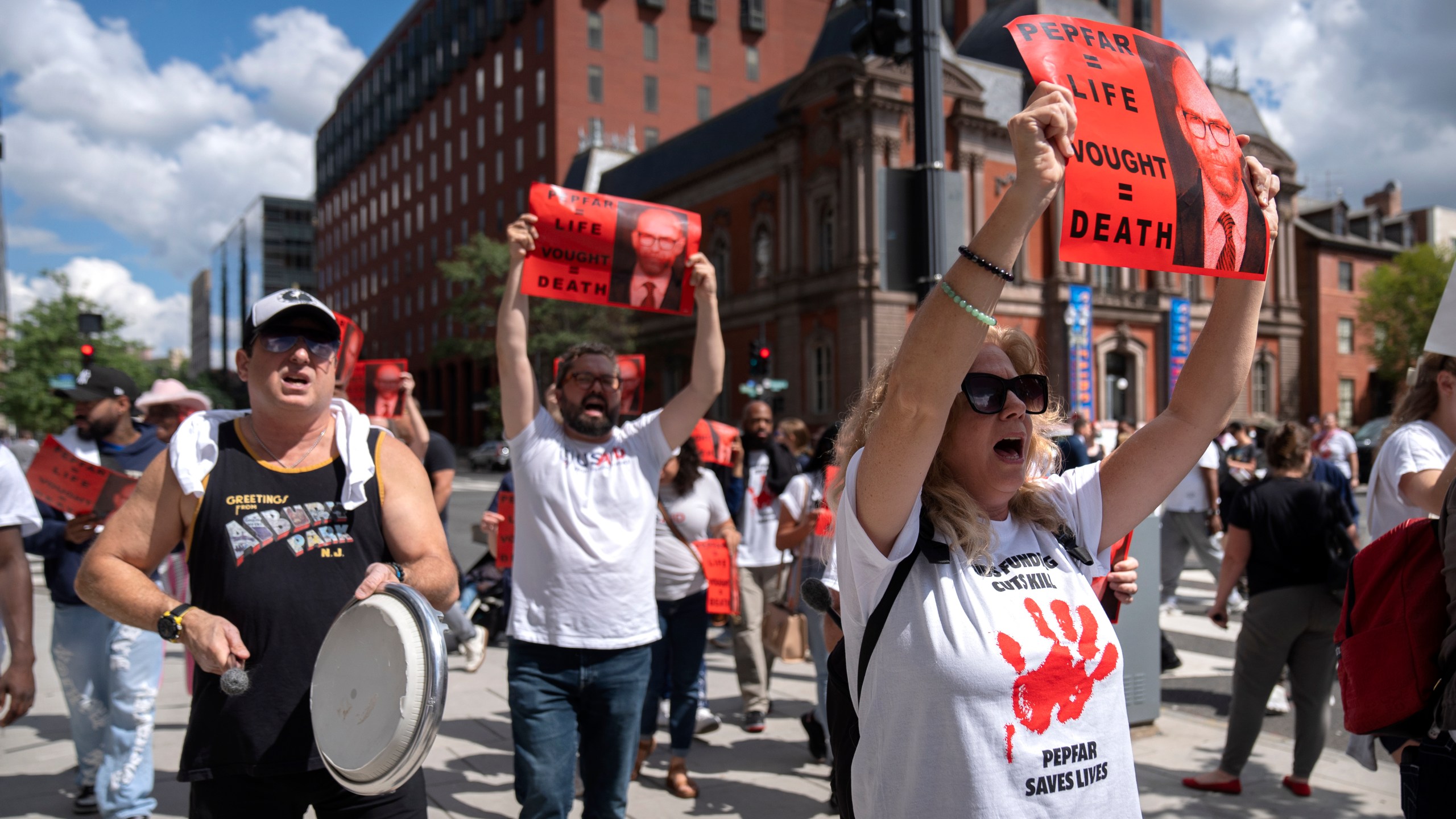Demonstrators protesting against the Trump administration's withholding of federal funds for the PEPFAR program to combat HIV/AIDS march near the White House, Tuesday, Sept. 2, 2025, in Washington. (AP Photo/Mark Schiefelbein)