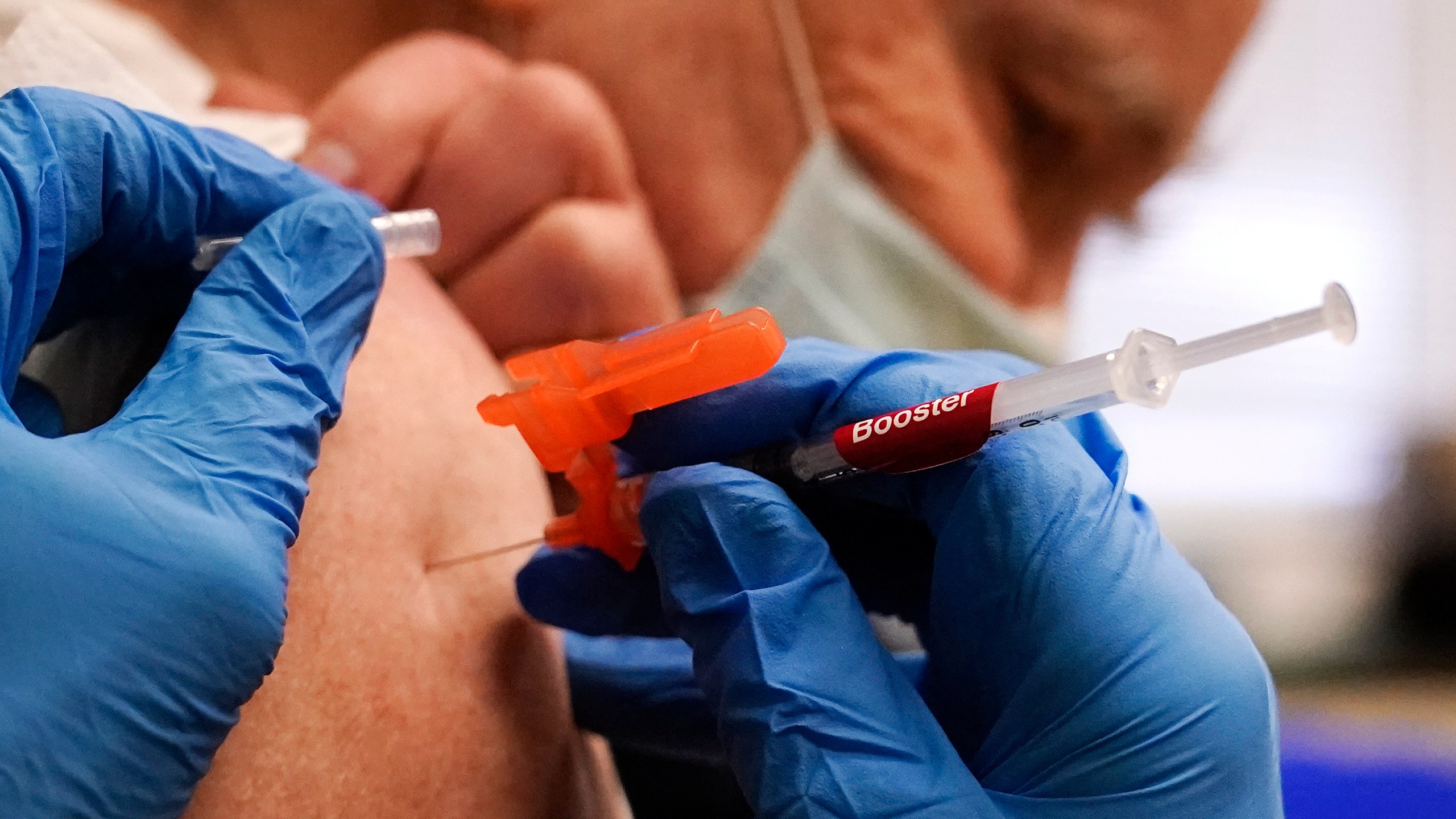 FILE - Pharmacist Kenni Clark injects Robert Champion, of Lawrence, Mass., with a booster dosage of the Moderna COVID-19 vaccine during a vaccination clinic at City of Lawrence's "The Center," Dec. 29, 2021, in Lawrence, Mass. (AP Photo/Charles Krupa, File)