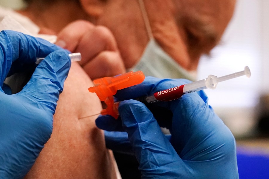 FILE - Pharmacist Kenni Clark injects Robert Champion, of Lawrence, Mass., with a booster dosage of the Moderna COVID-19 vaccine during a vaccination clinic at City of Lawrence's "The Center," Dec. 29, 2021, in Lawrence, Mass. (AP Photo/Charles Krupa, File)