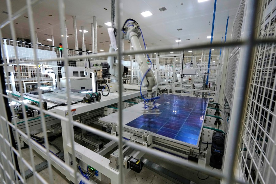 A robot places solar cells on a glass panel at a ReNew manufacturing plant on the outskirts of Jaipur, India, Thursday, Aug. 21, 2025. (AP Photo/Manish Swarup)