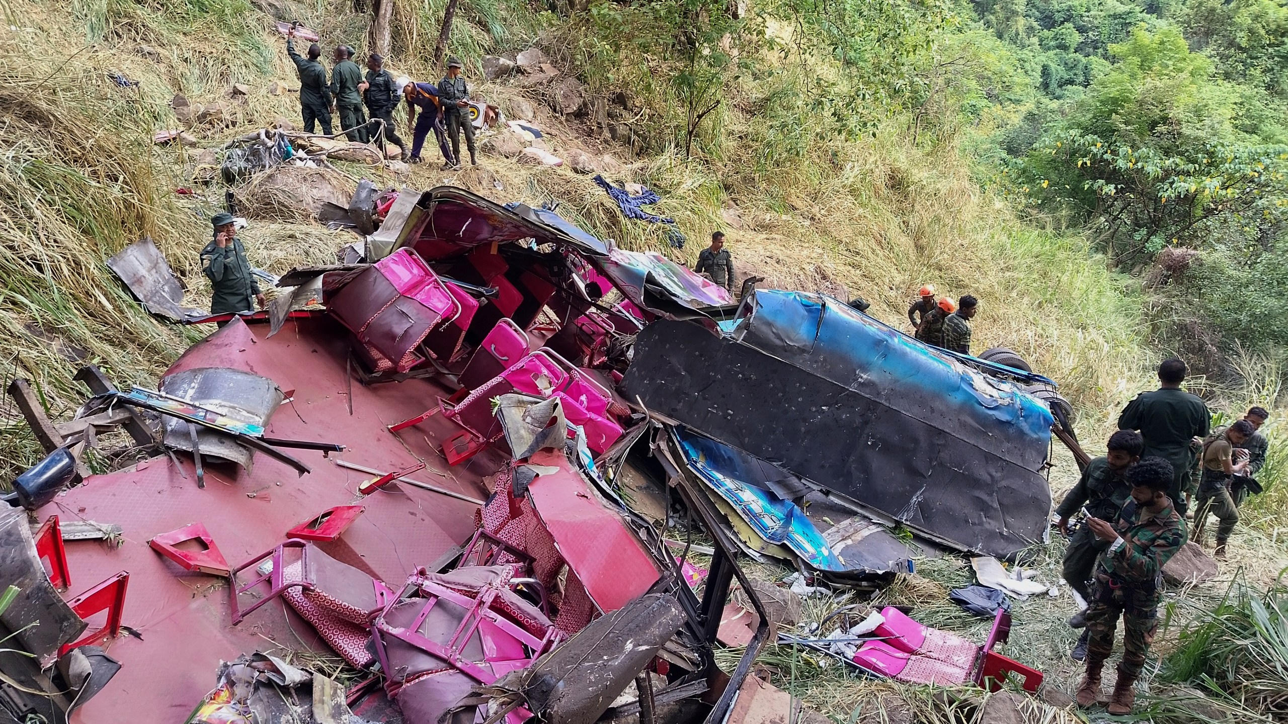 Soldiers and rescue workers stand by the debris of a passenger bus after it plunged into a precipice in Wellawaya, Sri Lanka, Friday, Sept. 5, 2025. (AP Photo/Prasanna Pathmasiri)