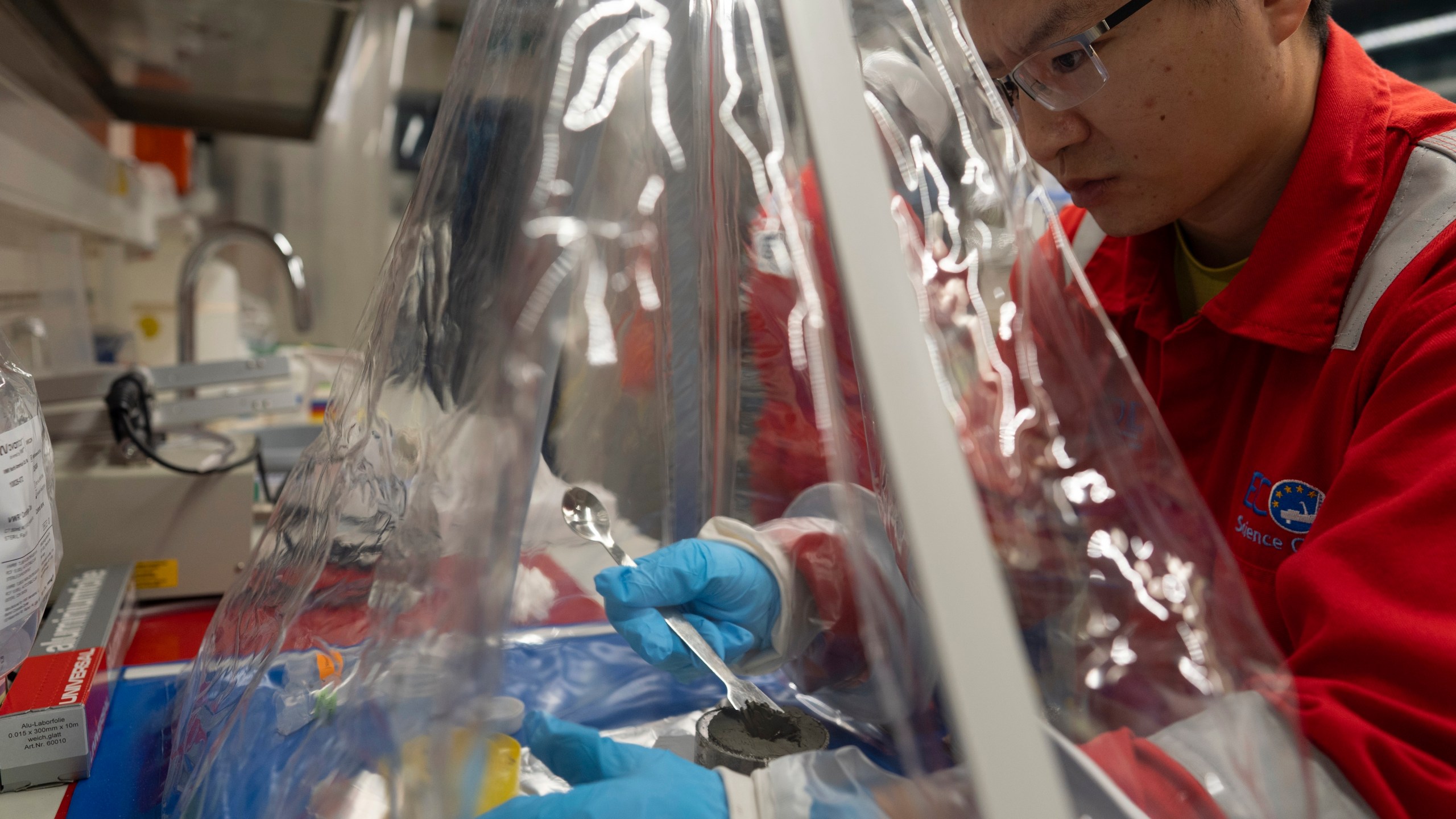 Expedition 501 researchers Xinxu Zhang, of Shenzhen University China, works in a container to ensure a sterile environment aboard the Liftboat Robert platform, in the North Atlantic, Sunday, July 20, 2025. (AP Photo/Carolyn Kaster)