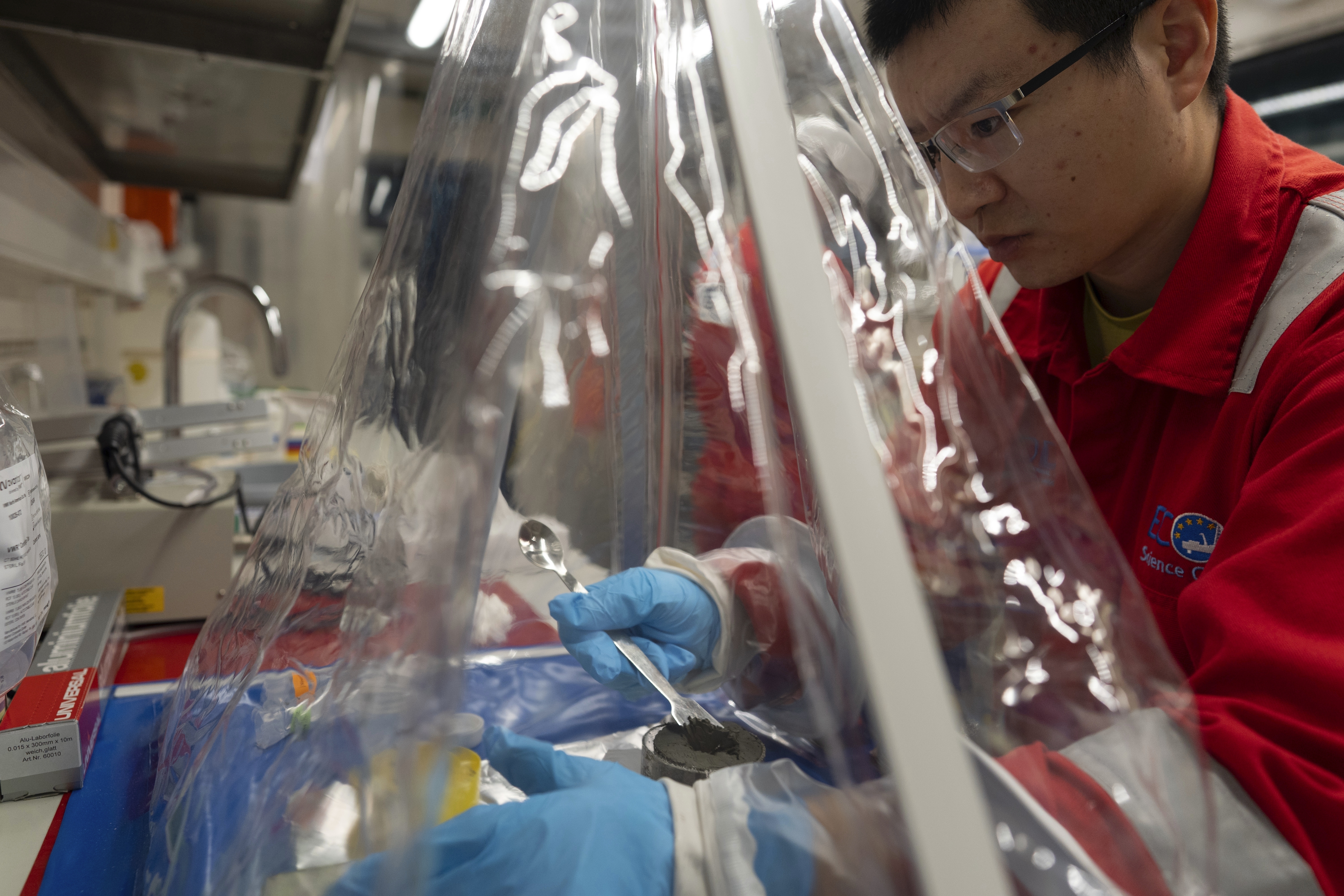 Expedition 501 researchers Xinxu Zhang, of Shenzhen University China, works in a container to ensure a sterile environment aboard the Liftboat Robert platform, in the North Atlantic, Sunday, July 20, 2025. (AP Photo/Carolyn Kaster)