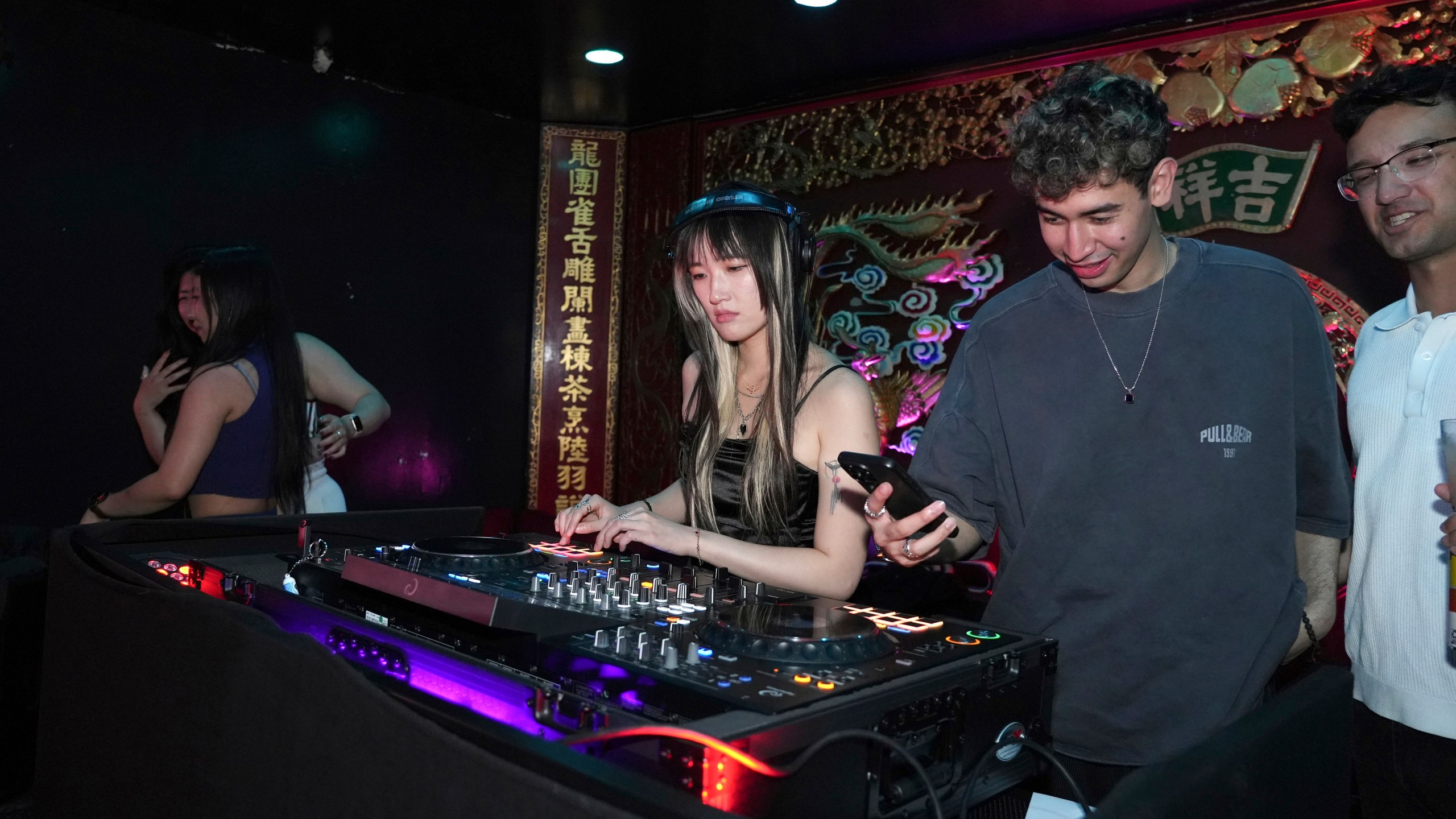 A DJ plays music at an event organized by the YLL Mahjong Club on Friday, Aug. 15, 2025, in San Francisco. (AP Photo/Terry Chea)
