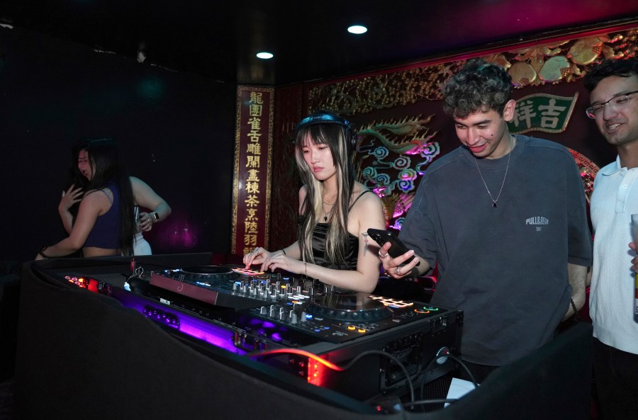 A DJ plays music at an event organized by the YLL Mahjong Club on Friday, Aug. 15, 2025, in San Francisco. (AP Photo/Terry Chea)
