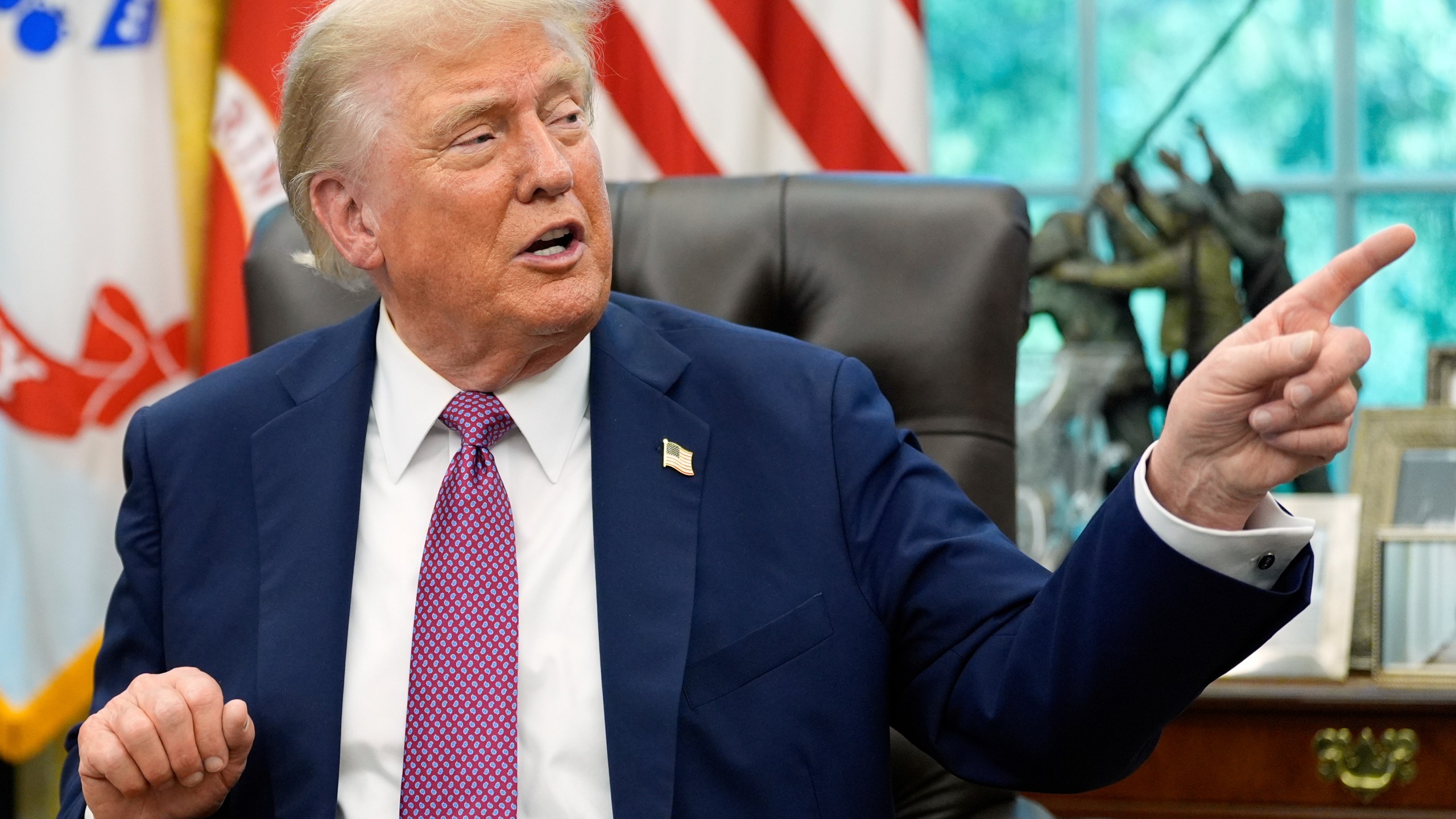President Donald Trump point to a G20 Miami 2026 poster as he speaks in the Oval Office of the White House, Friday, Sept. 5, 2025, in Washington. (AP Photo/Alex Brandon)