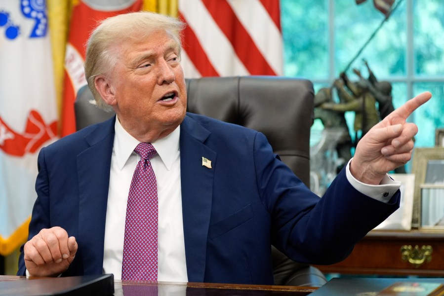 President Donald Trump point to a G20 Miami 2026 poster as he speaks in the Oval Office of the White House, Friday, Sept. 5, 2025, in Washington. (AP Photo/Alex Brandon)