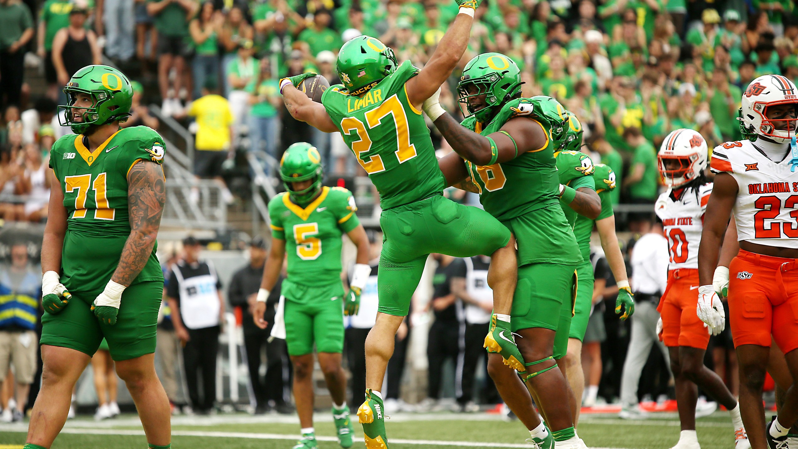 Oregon running back Jayden Limar (27) celebrates after his touchdown with offensive lineman Isaiah World, center right, during the first half of an NCAA college football game against Oklahoma State, Saturday, Sept. 6, 2025, in Eugene, Ore. (AP Photo/Lydia Ely)