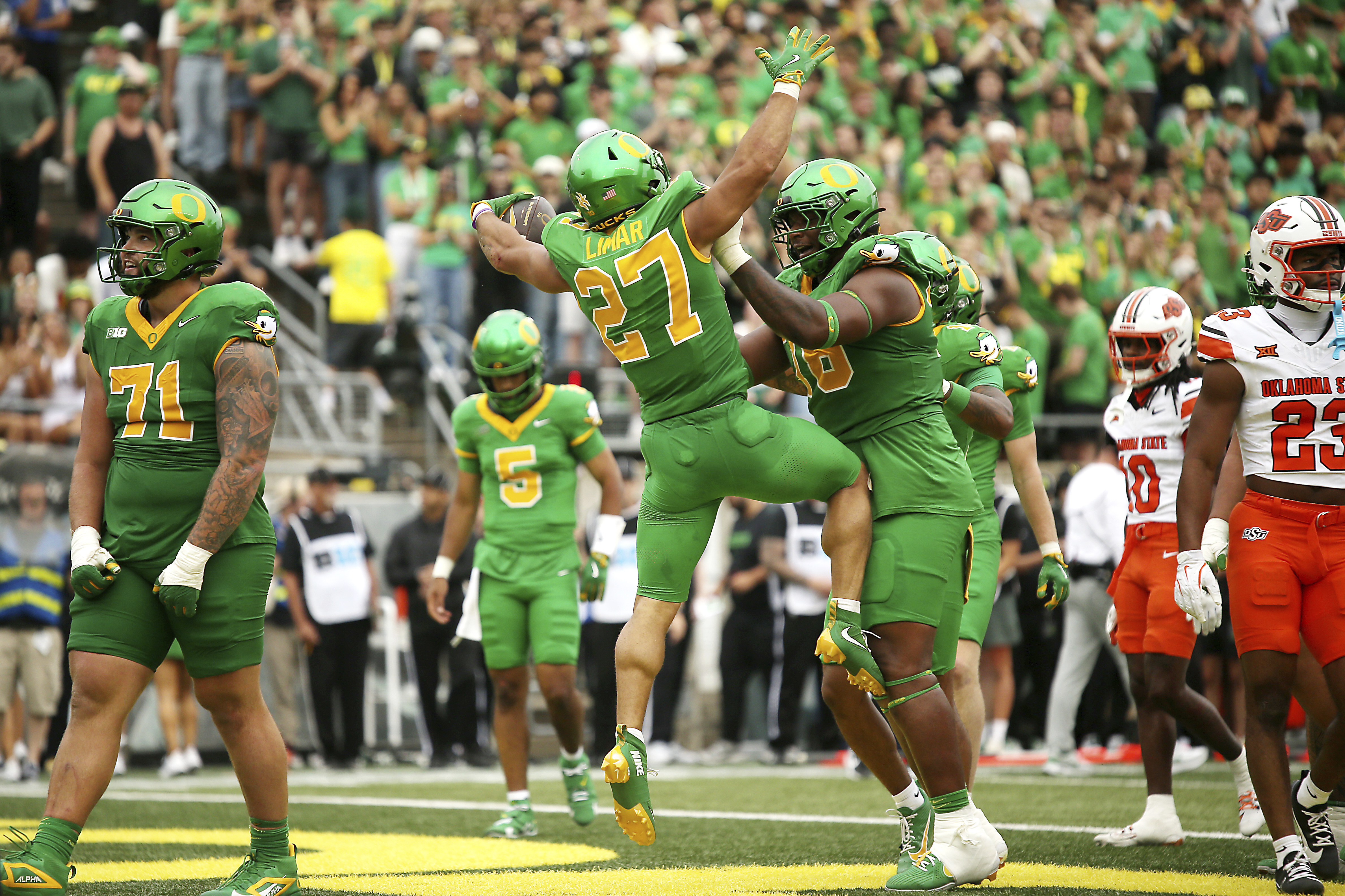 Oregon running back Jayden Limar (27) celebrates after his touchdown with offensive lineman Isaiah World, center right, during the first half of an NCAA college football game against Oklahoma State, Saturday, Sept. 6, 2025, in Eugene, Ore. (AP Photo/Lydia Ely)
