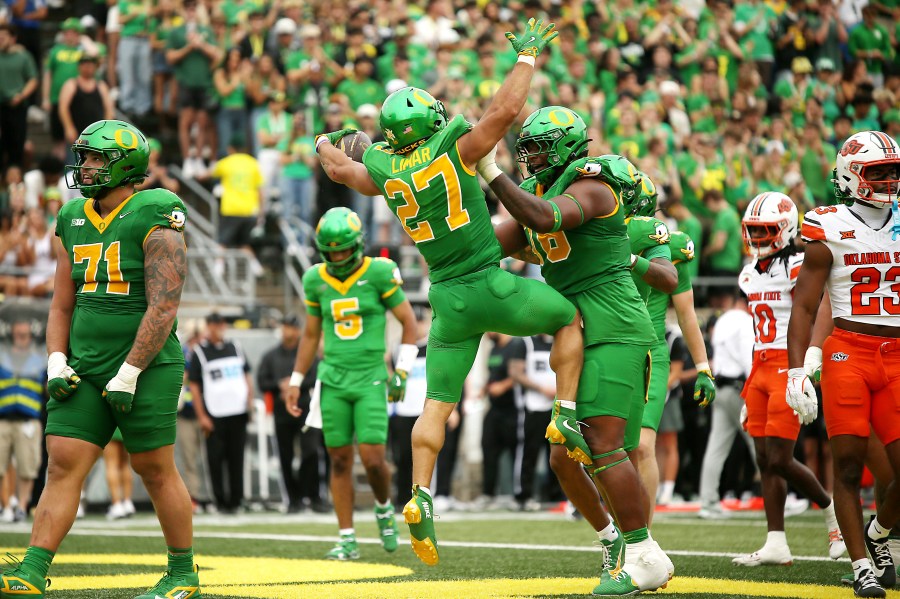 Oregon running back Jayden Limar (27) celebrates after his touchdown with offensive lineman Isaiah World, center right, during the first half of an NCAA college football game against Oklahoma State, Saturday, Sept. 6, 2025, in Eugene, Ore. (AP Photo/Lydia Ely)