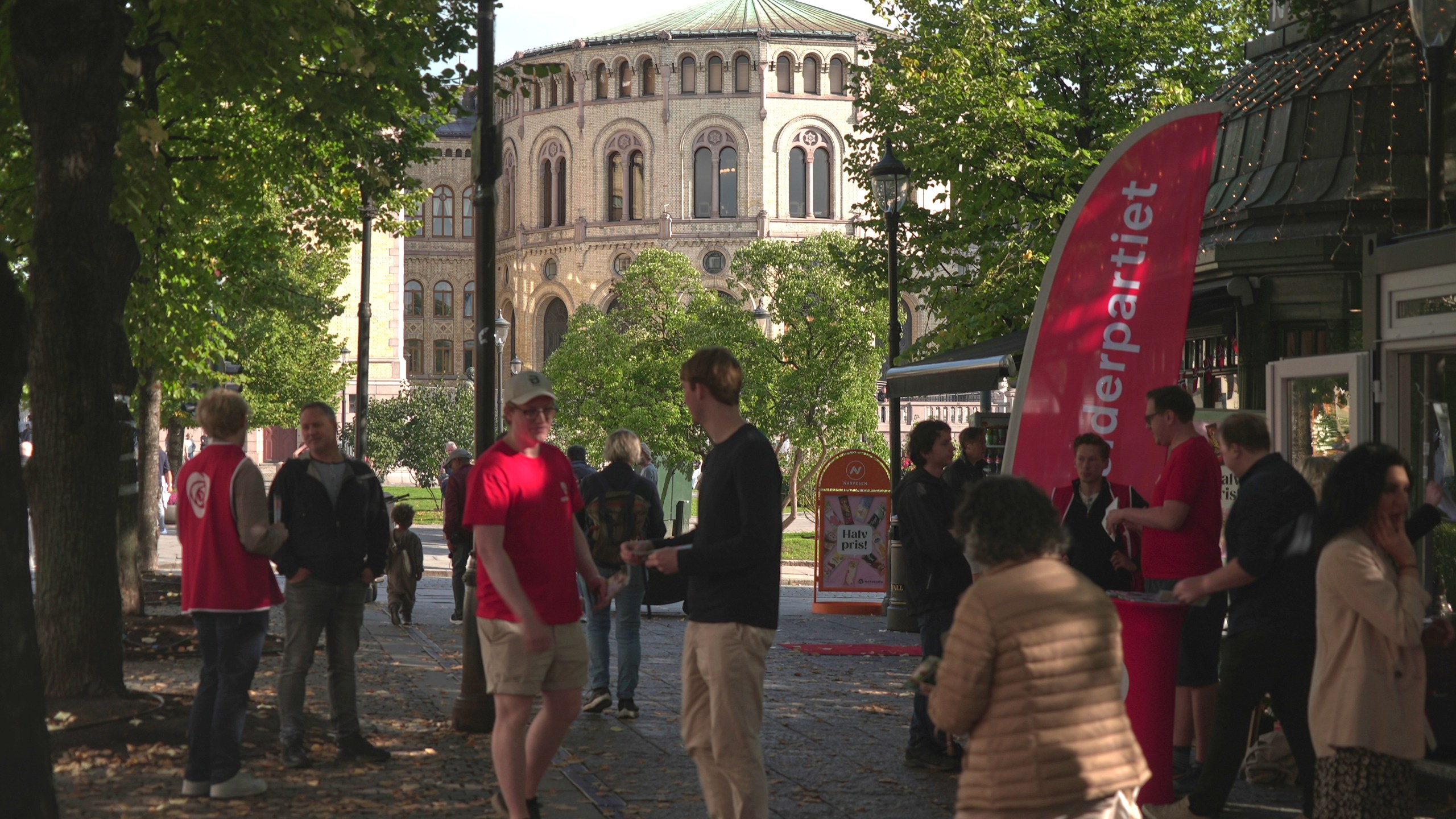 Campaign volunteers from the Labour Party, wearing red, engage with people near the Norwegian Parliament building in Oslo, Sunday, Sept. 7, 2025. (AP Photo/Kostya Manenkov)
