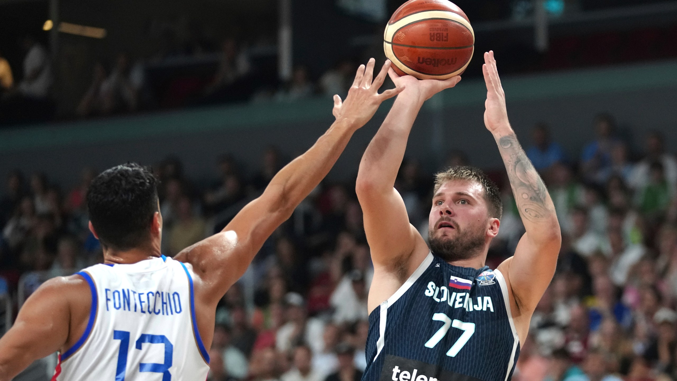 Slovenia's Luka Doncic tries to shoot while defended by Italy's Simone Fontecchio during the Eurobasket, European Basketball Championship round of 16 match between Italy and Slovenia at the Riga Arena in Riga, Latvia, Sunday, Sept. 7, 2025. (AP Photo/Sergei Grits)