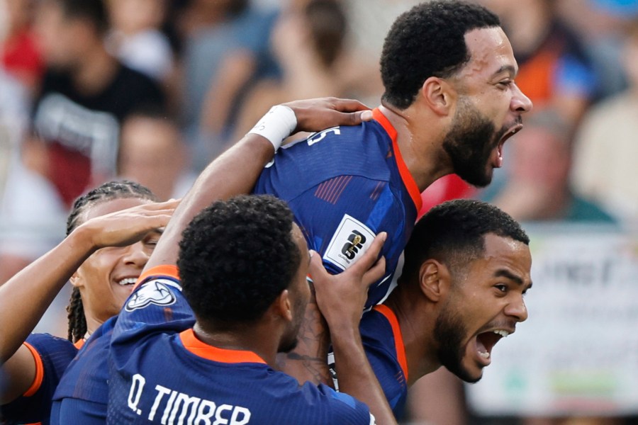 Dutch players celebrate their side's first goal scored by Memphis Depay, top, during the World Cup qualifying soccer match between Lithuania and Netherlands at Darius and Girenas stadium in Kaunas, Lithuania, Sunday, Sept. 7, 2025. (AP Photo/Mindaugas Kulbis)