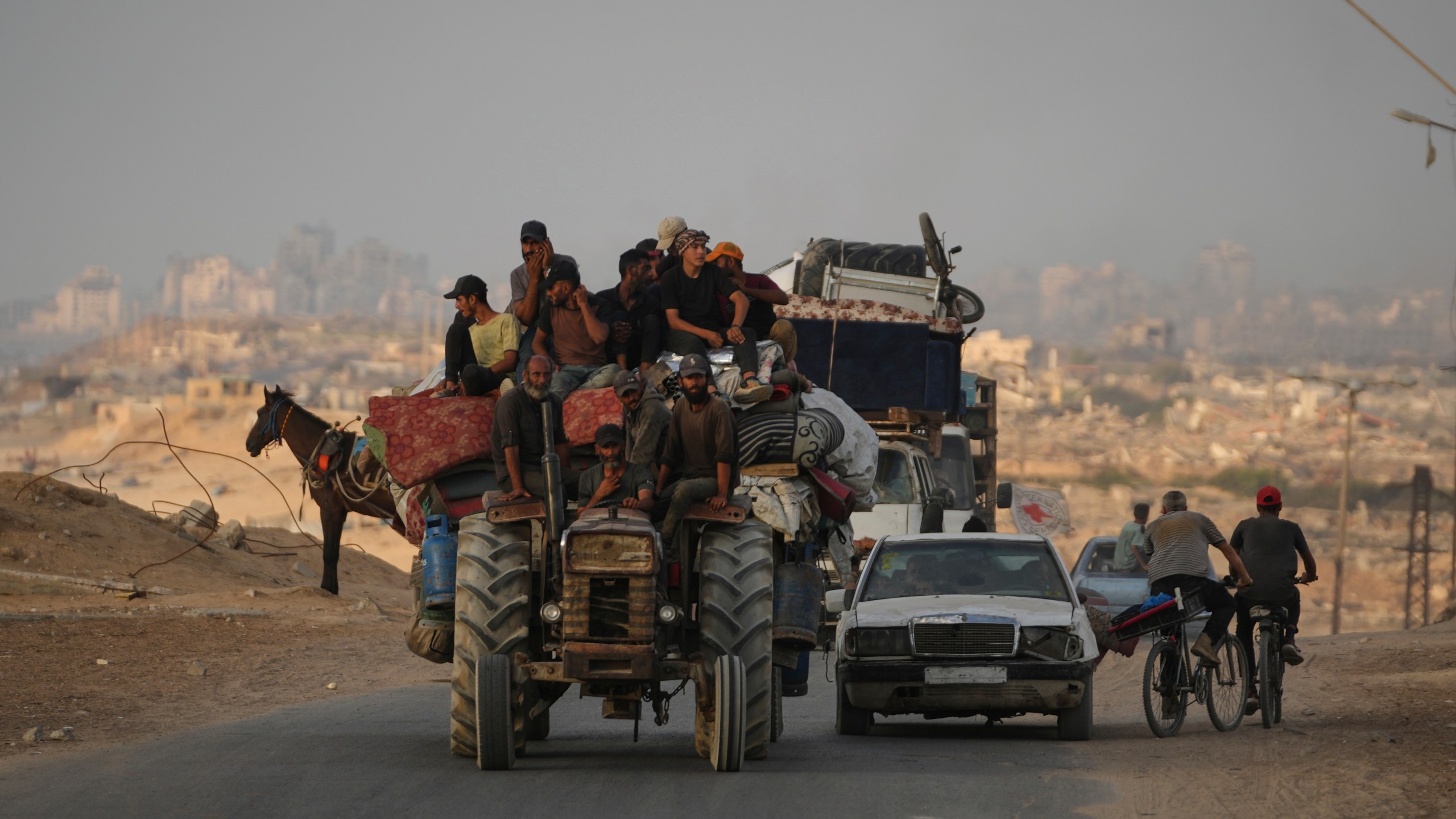Displaced Palestinians fleeing northern Gaza carry their belongings along the coastal road toward southern Gaza, Saturday, Sept. 6, 2025. (AP Photo/Jehad Alshrafi)