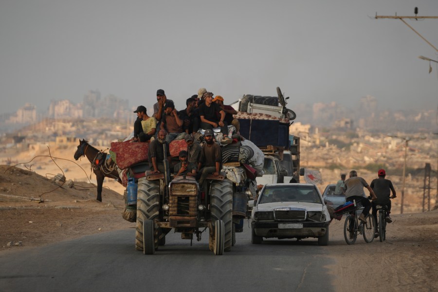 Displaced Palestinians fleeing northern Gaza carry their belongings along the coastal road toward southern Gaza, Saturday, Sept. 6, 2025. (AP Photo/Jehad Alshrafi)