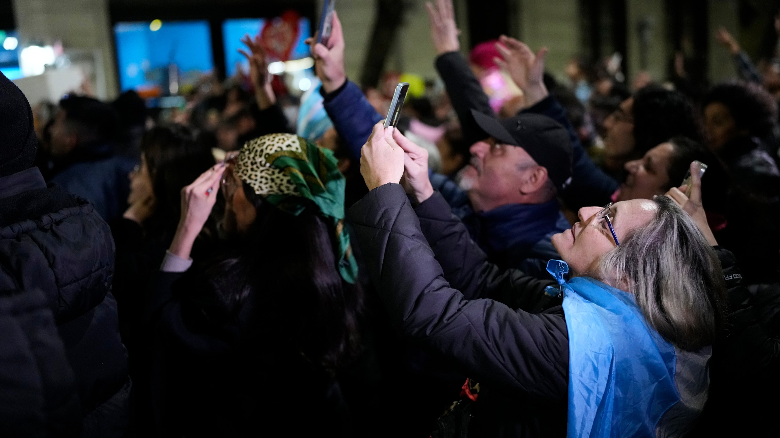 Supporters of former President Cristina Fernandez take pictures of her at the balcony of her home where she is serving a six-year house arrest sentence for corruption, after legislative provincial election polls closed, in Buenos Aires, Argentina, Sunday, Sept. 7, 2025. (AP Photo/Natacha Pisarenko)