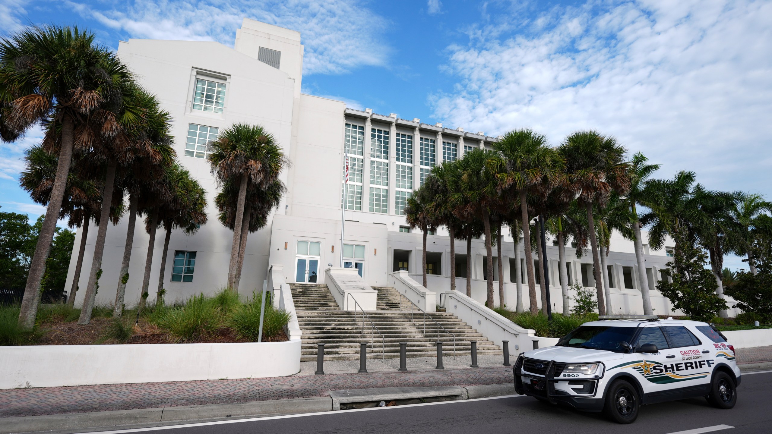 A police car drives past the Alto Lee Adams Sr. U.S. Courthouse as jury selection began in the trial of Ryan Routh, charged with trying to assassinate Donald Trump while he played golf last year in South Florida, Monday, Sept. 8, 2025, in Fort Pierce, Fla. (AP Photo/Rebecca Blackwell)