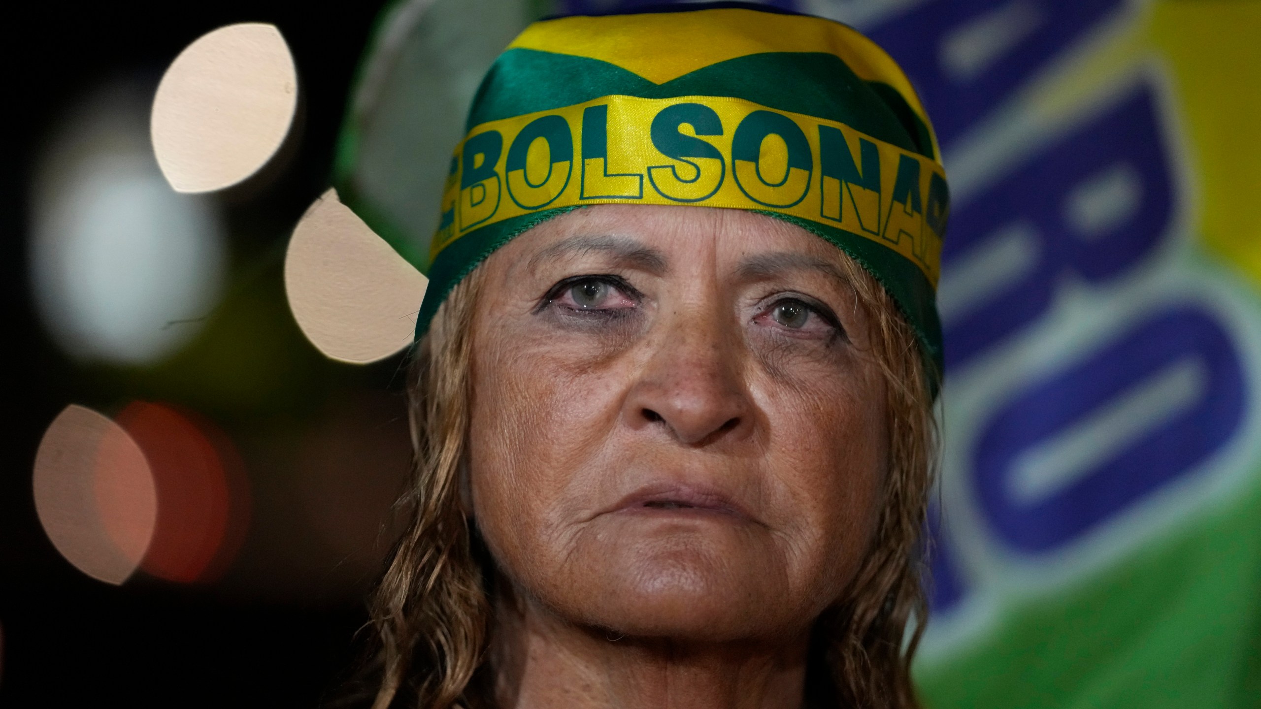A supporter of former President Jair Bolsonaro prays during a vigil in his support near his home where he is under house arrest, in Brasília, Brazil, Tuesday, Sept. 9, 2025. (AP Photo/Eraldo Peres)