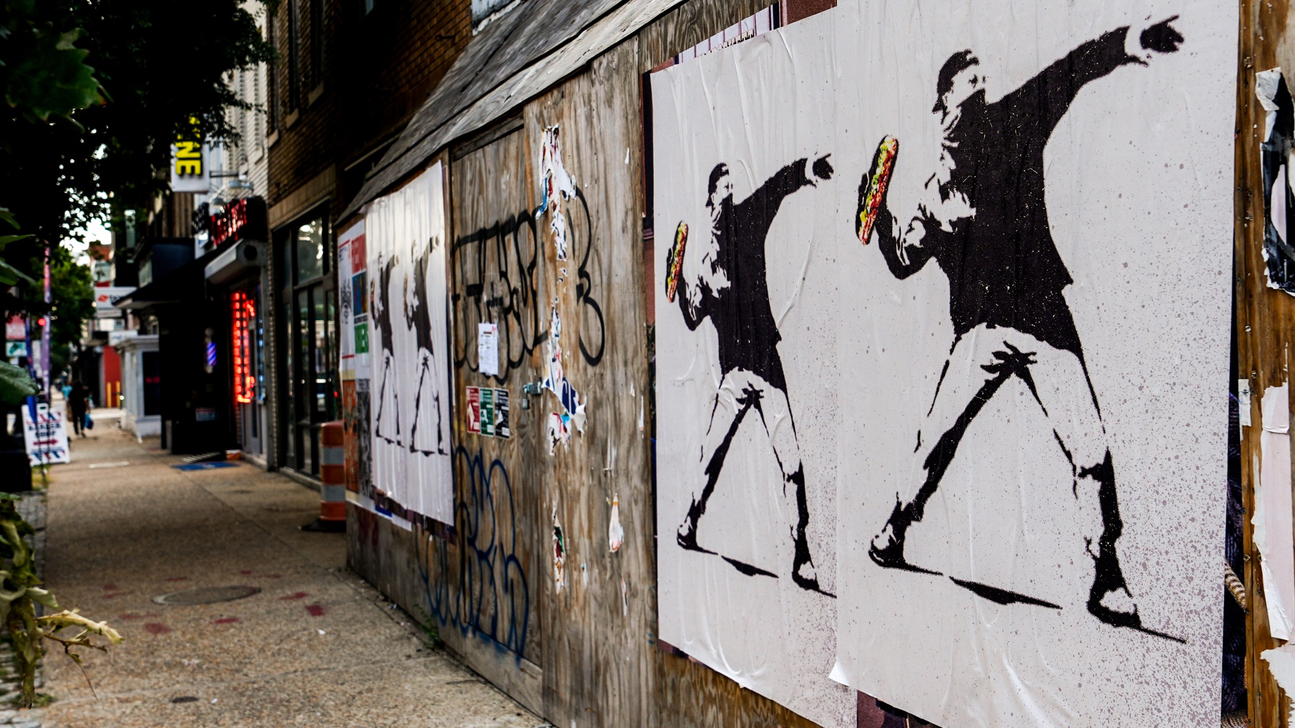 Posters of a person throwing a sandwich are pictured along H Street, Sunday, Aug. 17, 2025, in Washington. (AP Photo/Julia Demaree Nikhinson)