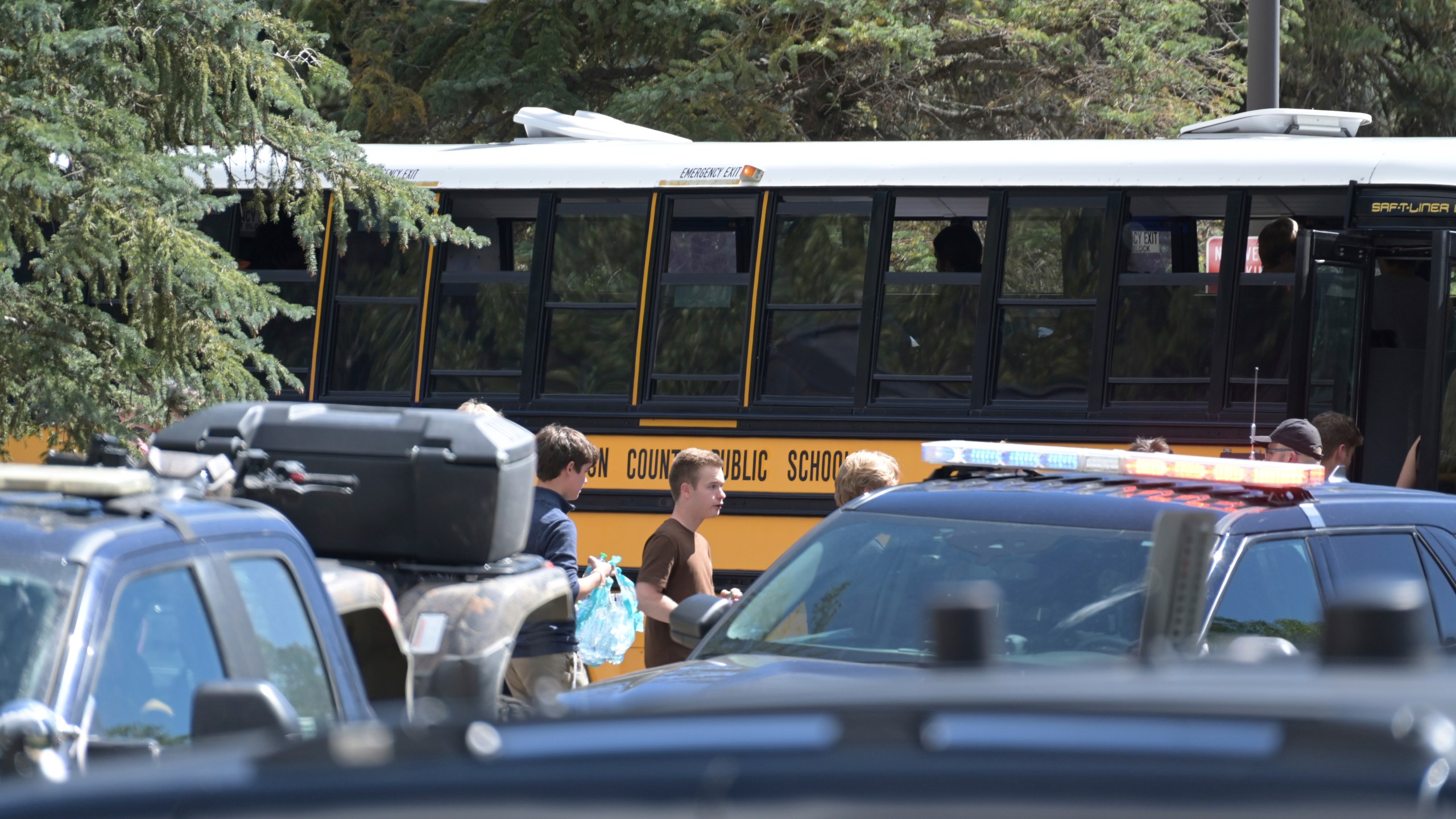 Students board a bus amid heavy police presence at the Evergreen Library after a shooting at Evergreen High School Wednesday, Sept. 10, 2025, in Evergreen, Colo. (Hyoung Chang/The Denver Post via AP)