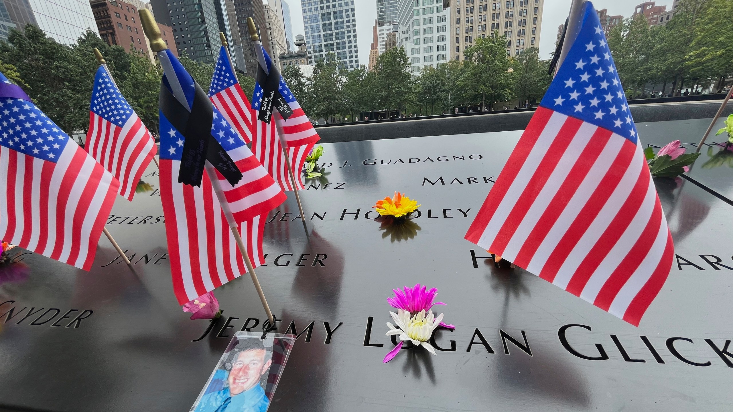 Flags and flowers are placed in the inscribed names at the National September 11 Memorial in New York on Wednesday, Sept. 10, 2025. (AP Photo/Donald King)