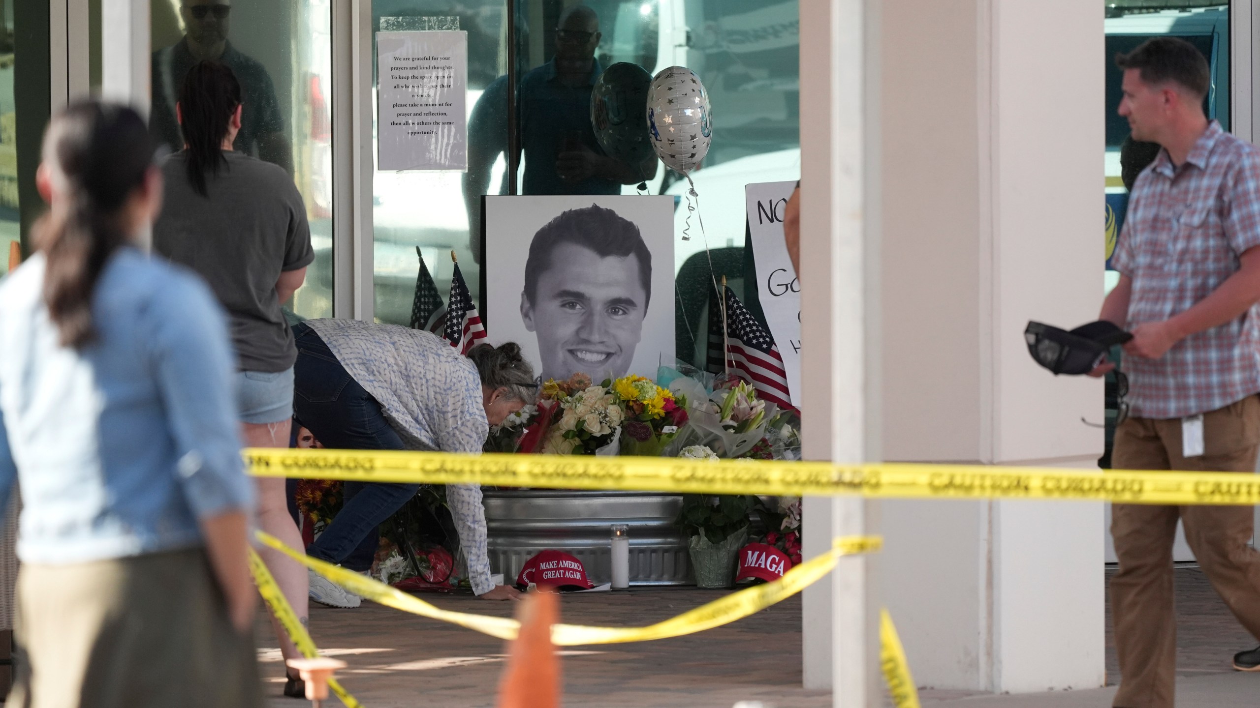 Well-wishers pay their respects at a makeshift memorial at the national headquarters of Turning Point USA after the shooting death of Charlie Kirk, CEO of the organization, during a Utah college event Wednesday, Sept. 10, 2025, in Phoenix. (AP Photo/Ross D. Franklin)