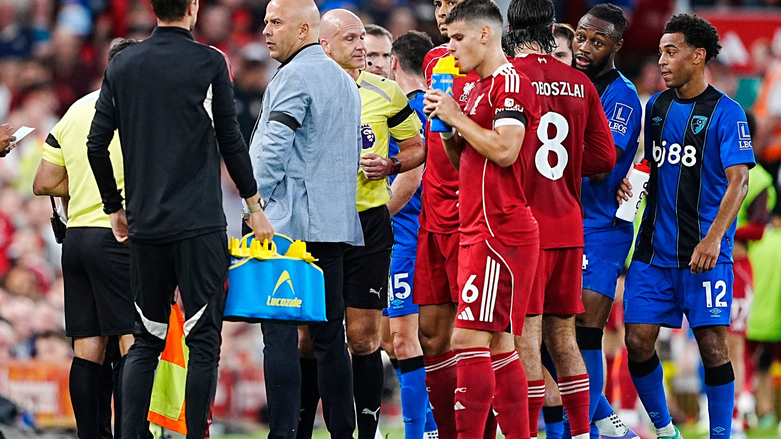 Referee Anthony Taylor during a stop in play after Bournemouth's Antoine Semenyo, second right, informs the referee of a possible racial comment from the crowd during the English Premier League soccer match between Liverpool and Bournemouth at Anfield, Liverpool, England, Friday Aug. 15, 2025. (Peter Byrne/PA via AP)