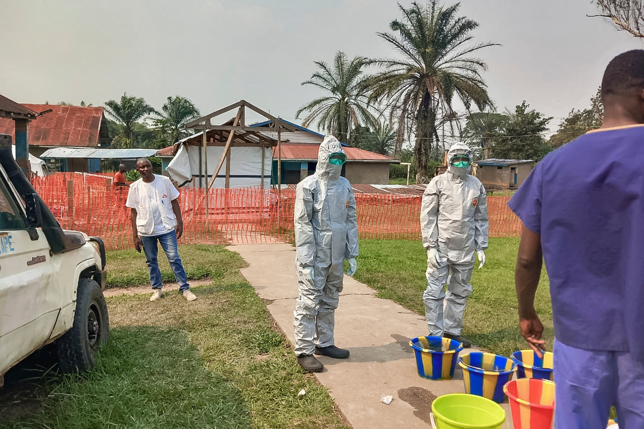 In this photo provided by Doctors Without Borders, men stand outside an Ebola treatment center in the remote Bulape Health Zone, Kasaï province, the Democratic Republic of Congo, Sunday, Sept 7, 2025, that was set up following the outbreak of the Zaire strain of the Ebola virus. (MSF via AP)