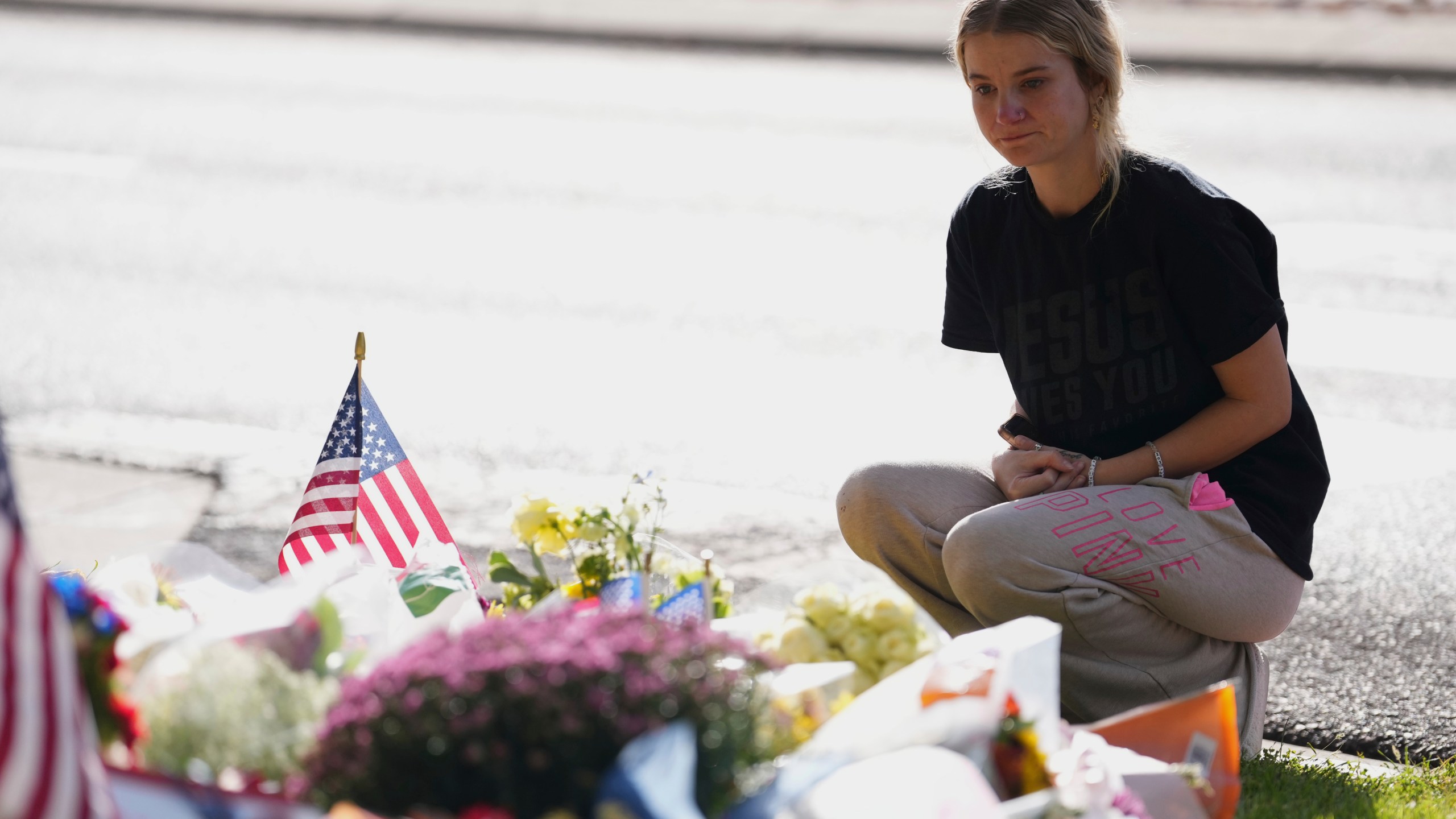 Meagan Bradley kneels at a memorial is set up for Charlie Kirk at Utah Valley University in Orem, Utah, Friday, Sept. 12, 2025. (AP Photo/Lindsey Wasson)